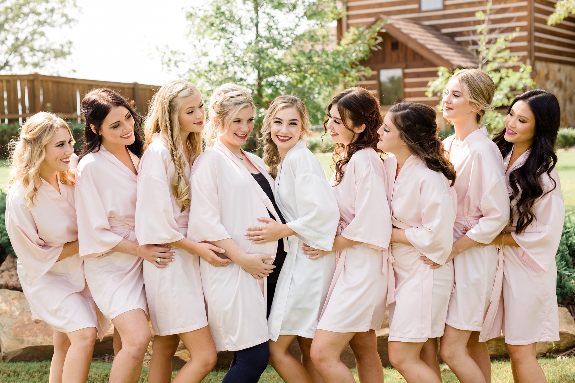 bride poses with bridesmaids in pink robes