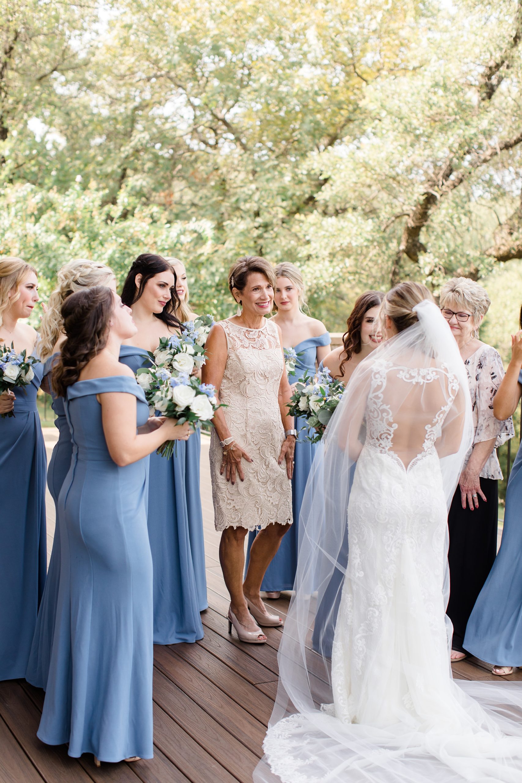 bride has first look with bridesmaids and stepmom