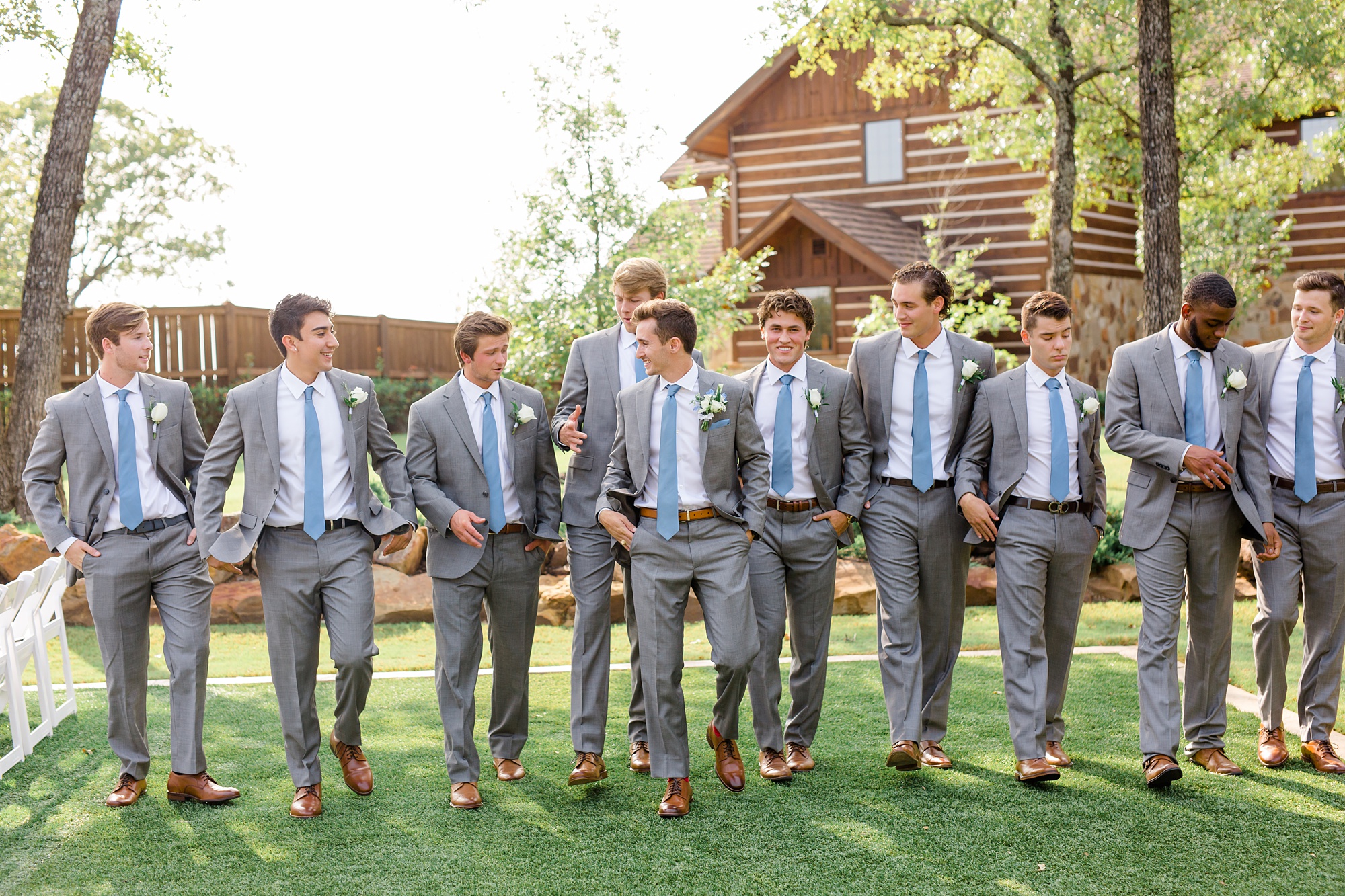 groom walks with groomsmen in grey suits and blue ties