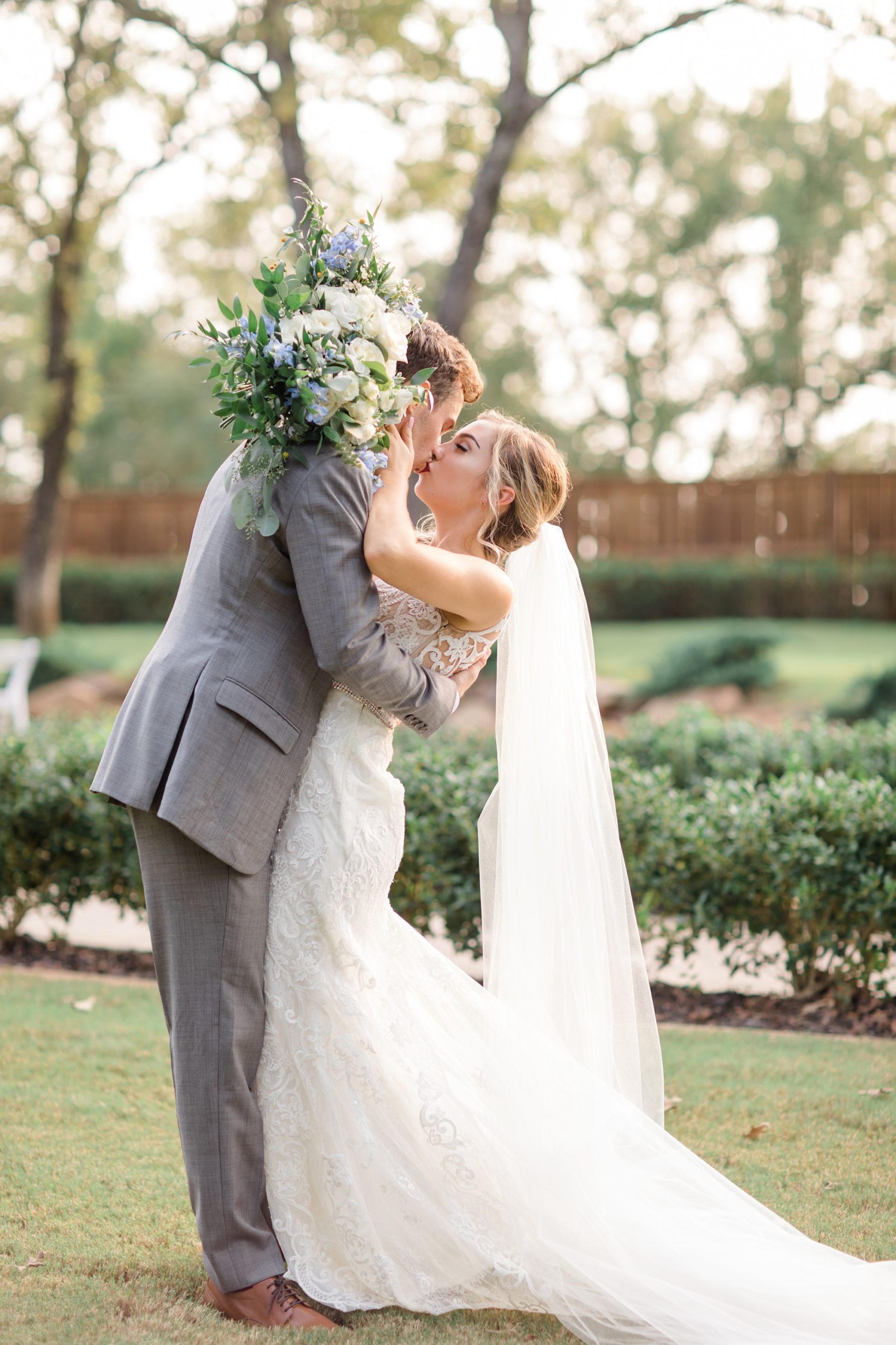bride and groom kiss during wedding portraits in Aubrey TX