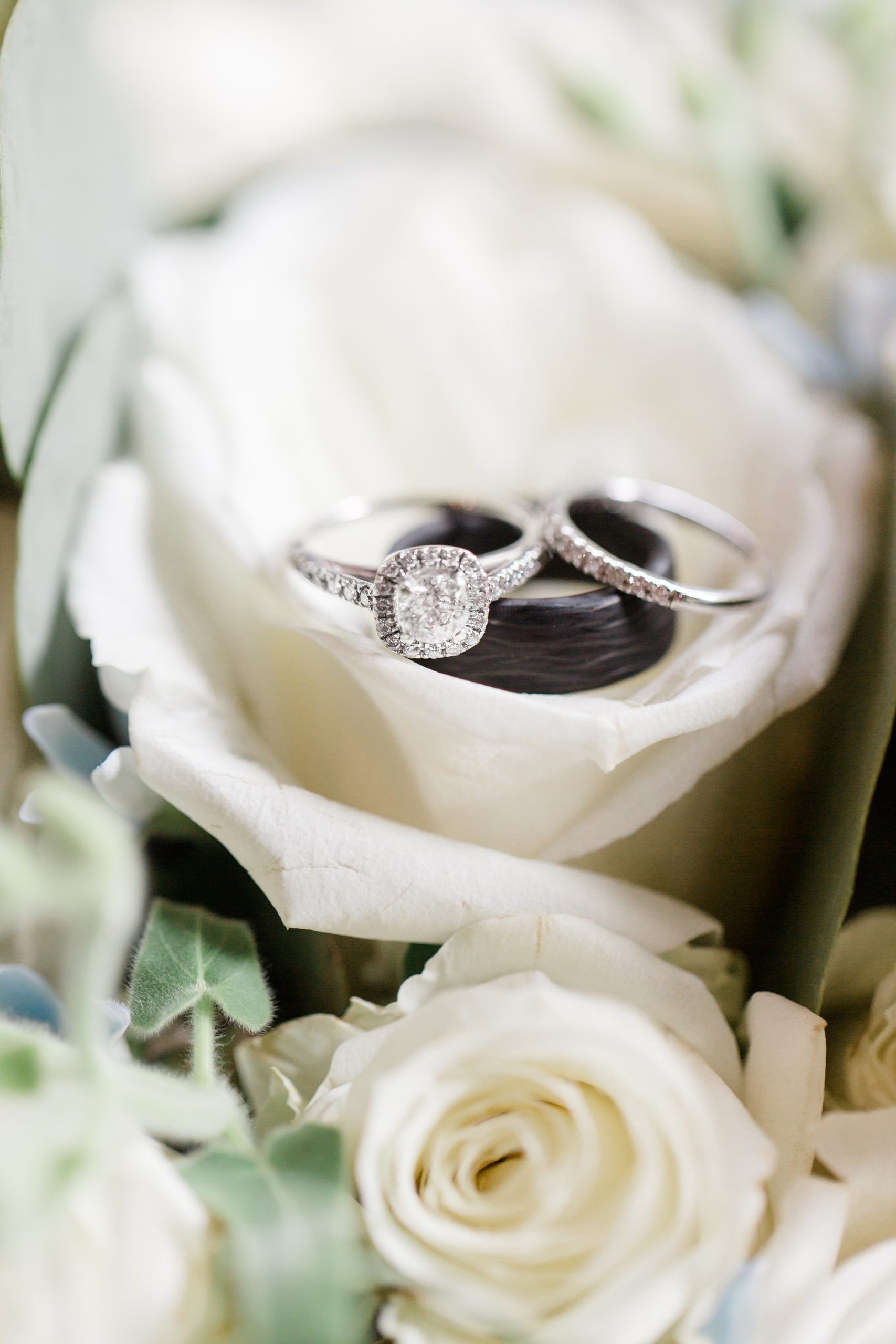 wedding rings rest on white flowers