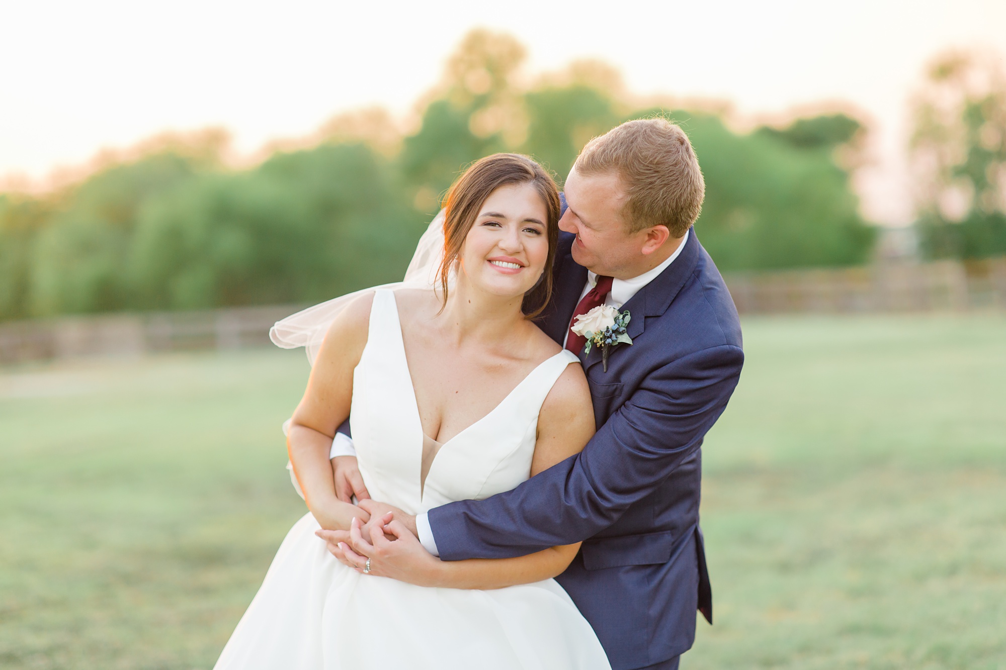 groom hugs bride and rocks her during photos