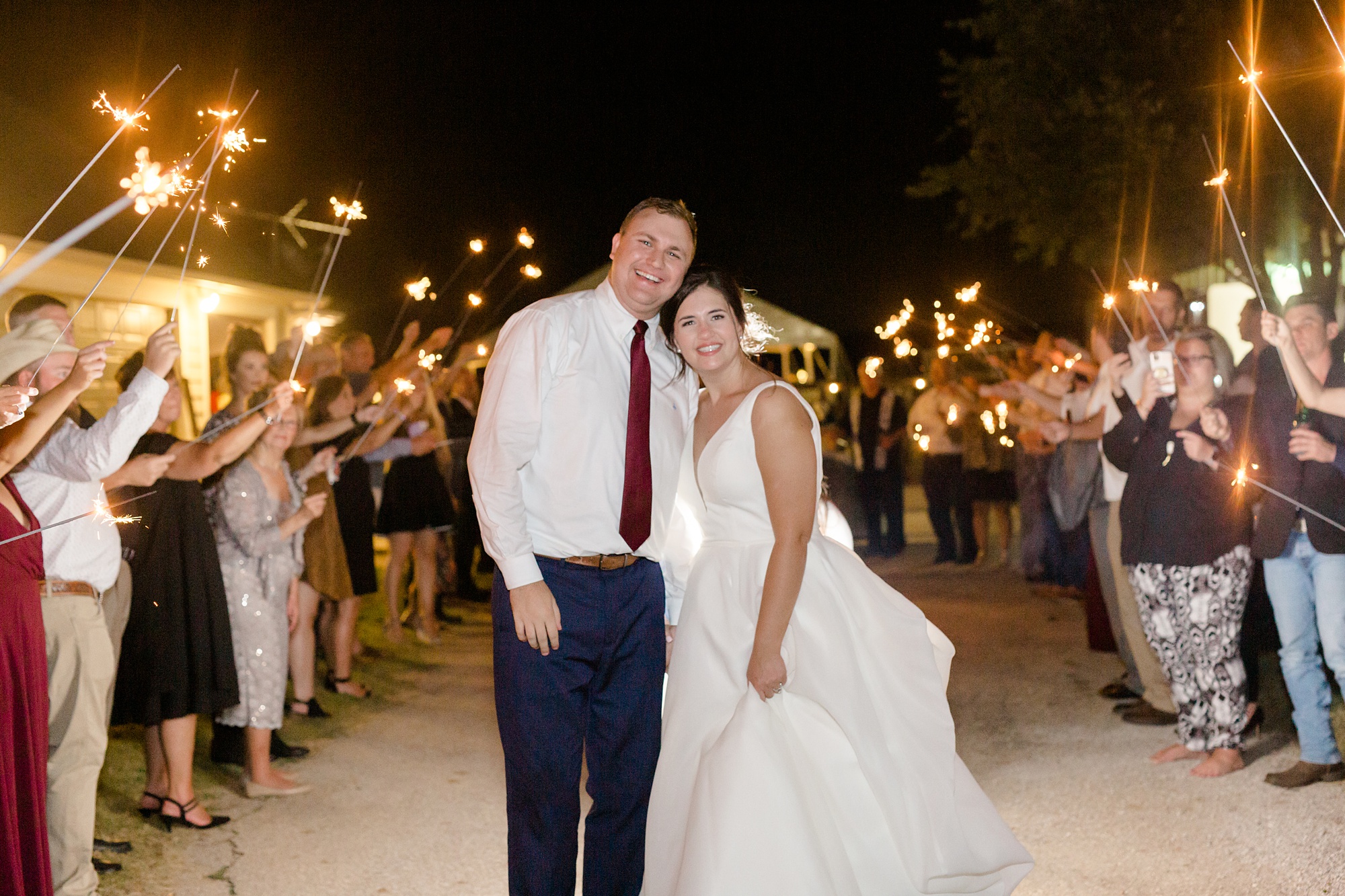 bride and groom pose during sparkler exit during Argyle TX wedding reception