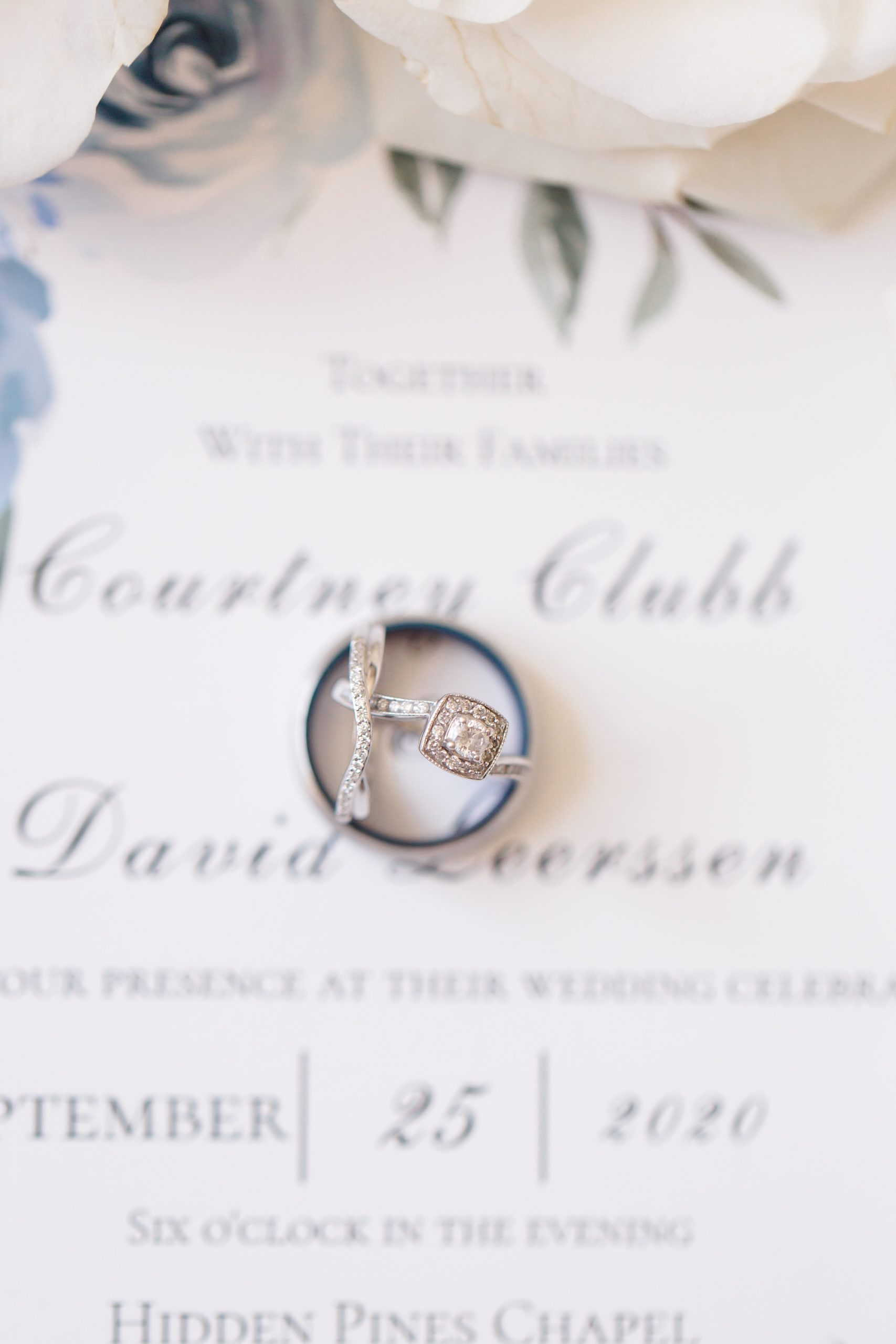 wedding rings rest on invitation for TX wedding