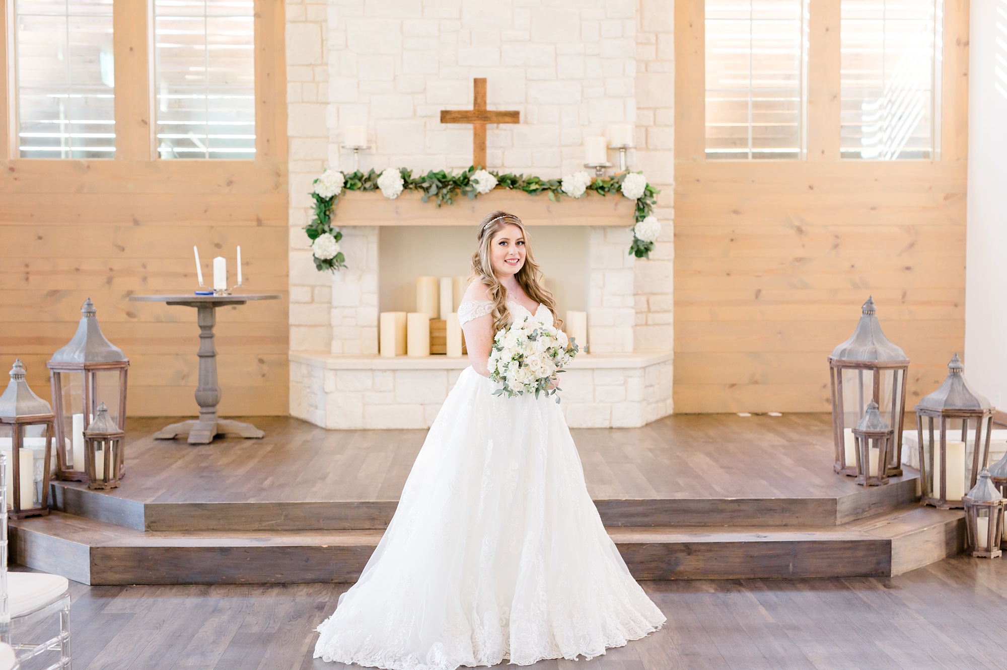 bride poses in front of chapel at Hidden Pines Highland Village