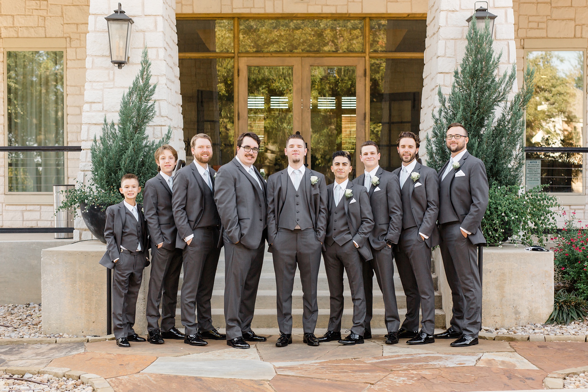 groom poses with groomsmen before Texas wedding