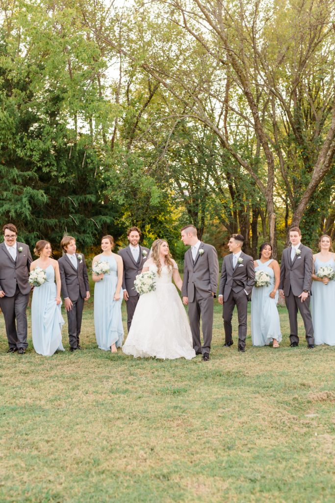 bridal party poses with bride and groom at Hidden Pines Highland Village
