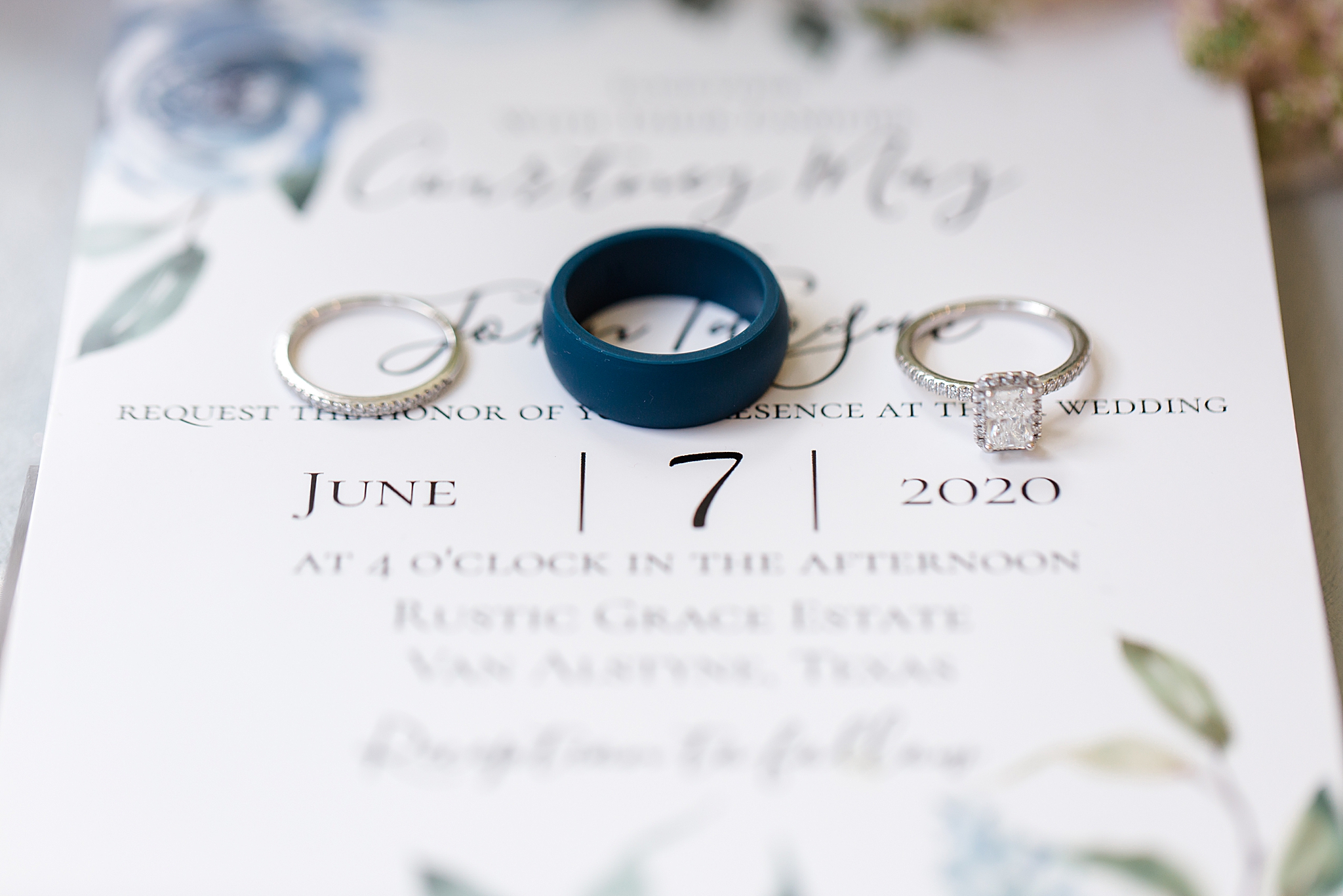wedding rings rest on wedding invitation 