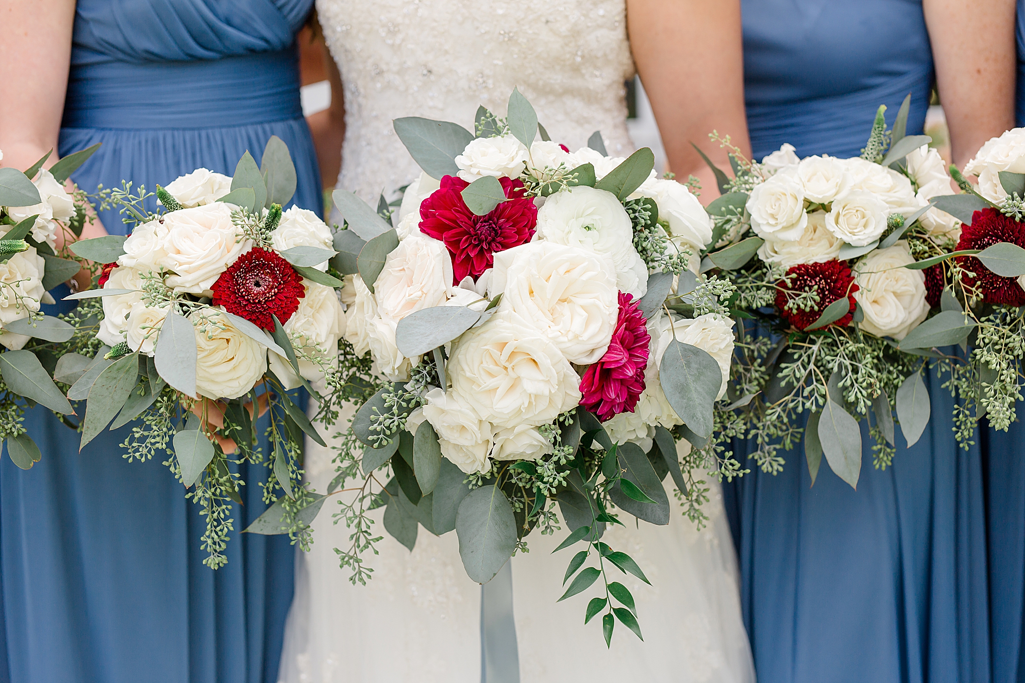 bridesmaids hold red and white bouquets