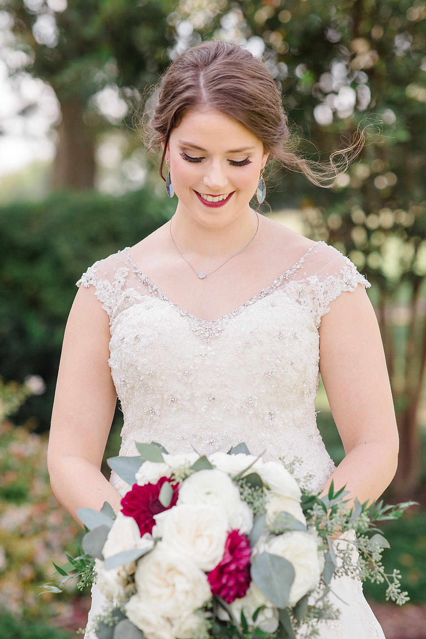 bride looks down at bouquet during bridal portraits