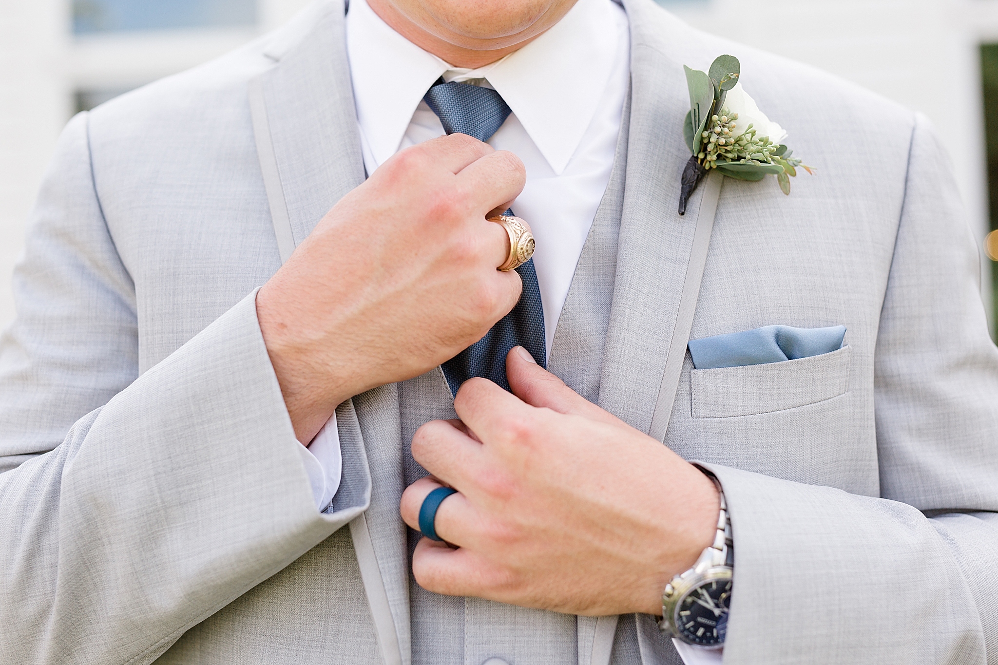 groom adjusts tie showing off Texas A & M ring