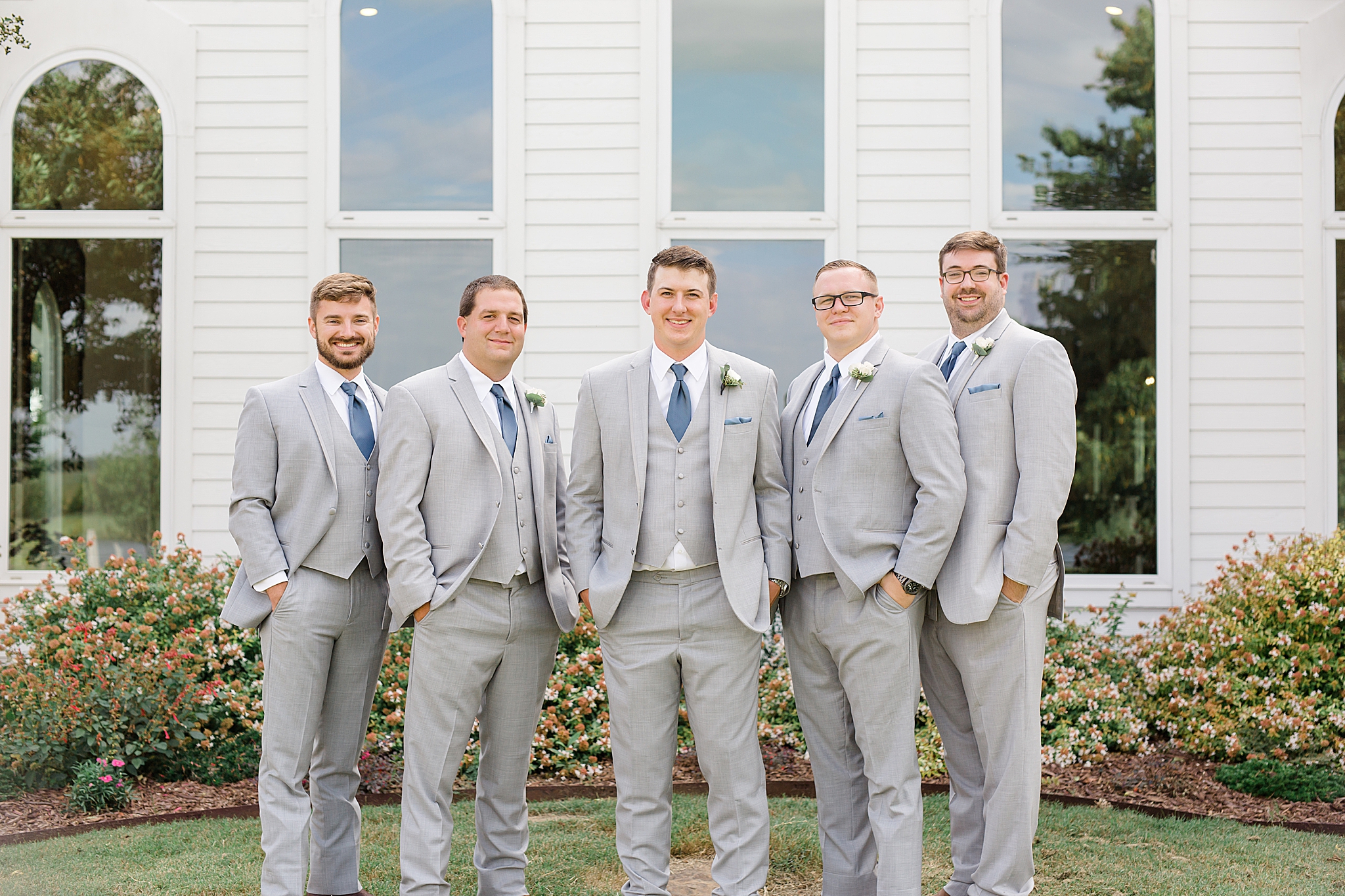 groom poses with groomsmen before Rustic Grace Estate wedding