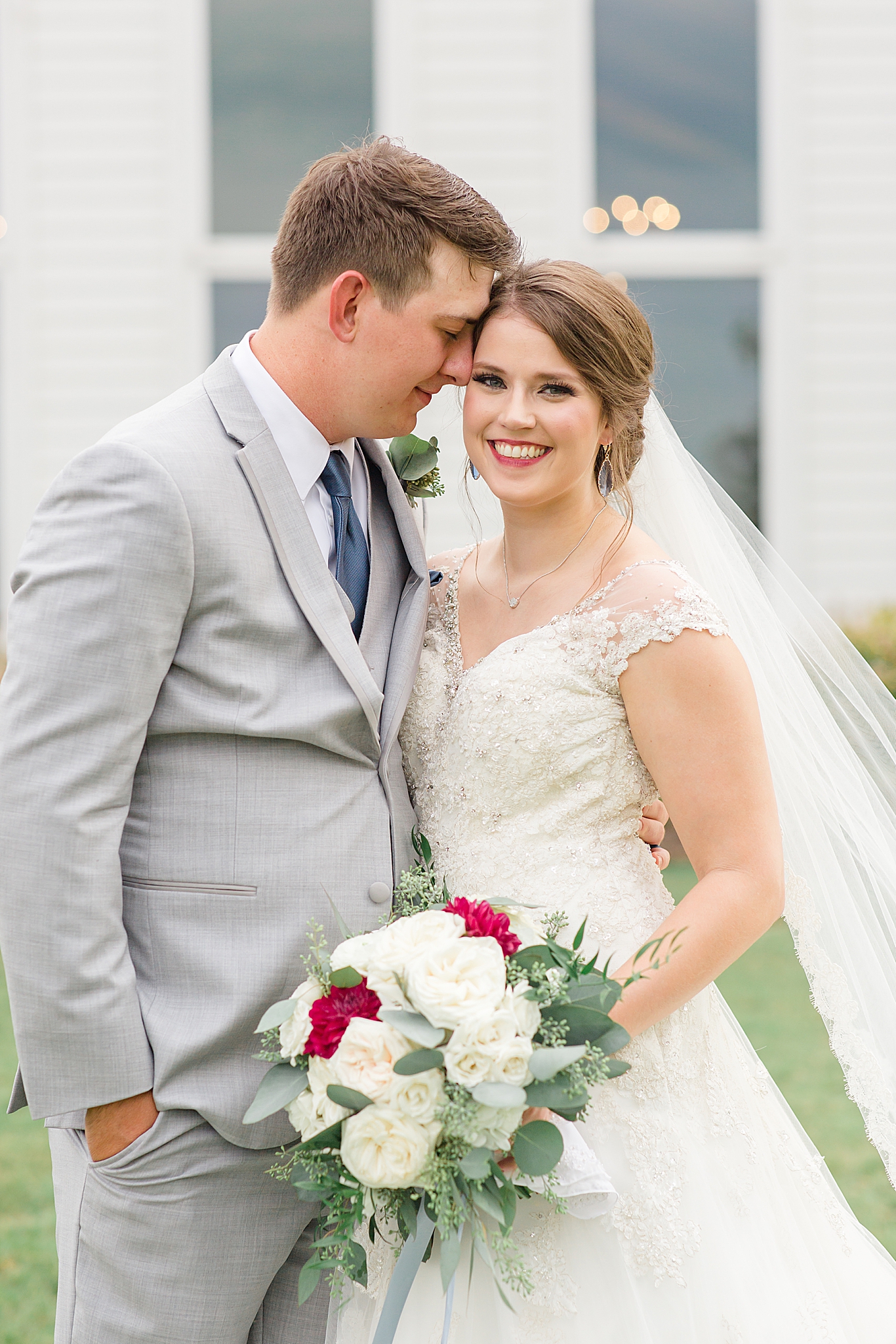 groom leans head against bride during wedding photos