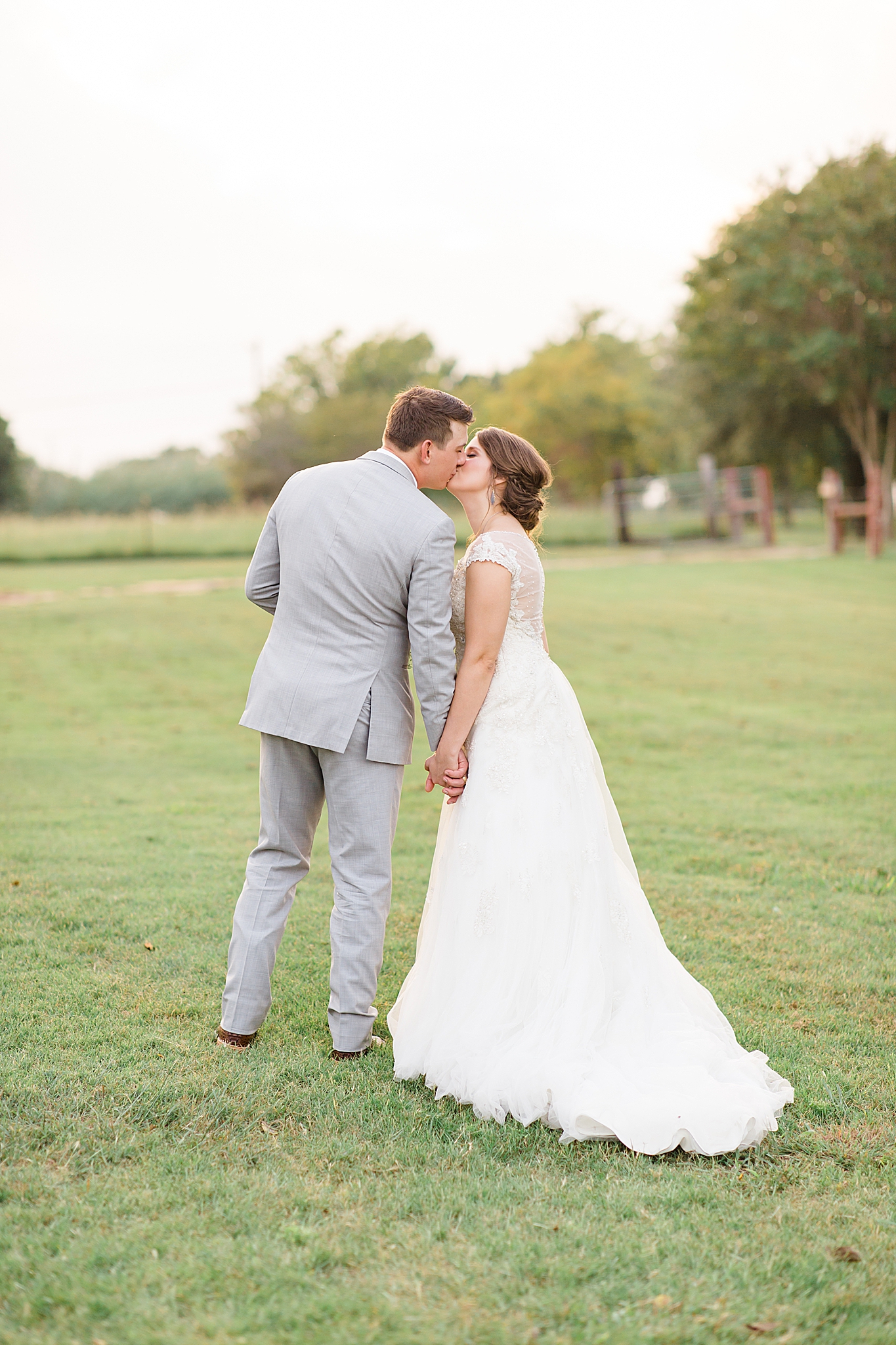 bride and groom stop to kiss during wedding photos at Rustic Grace Estate