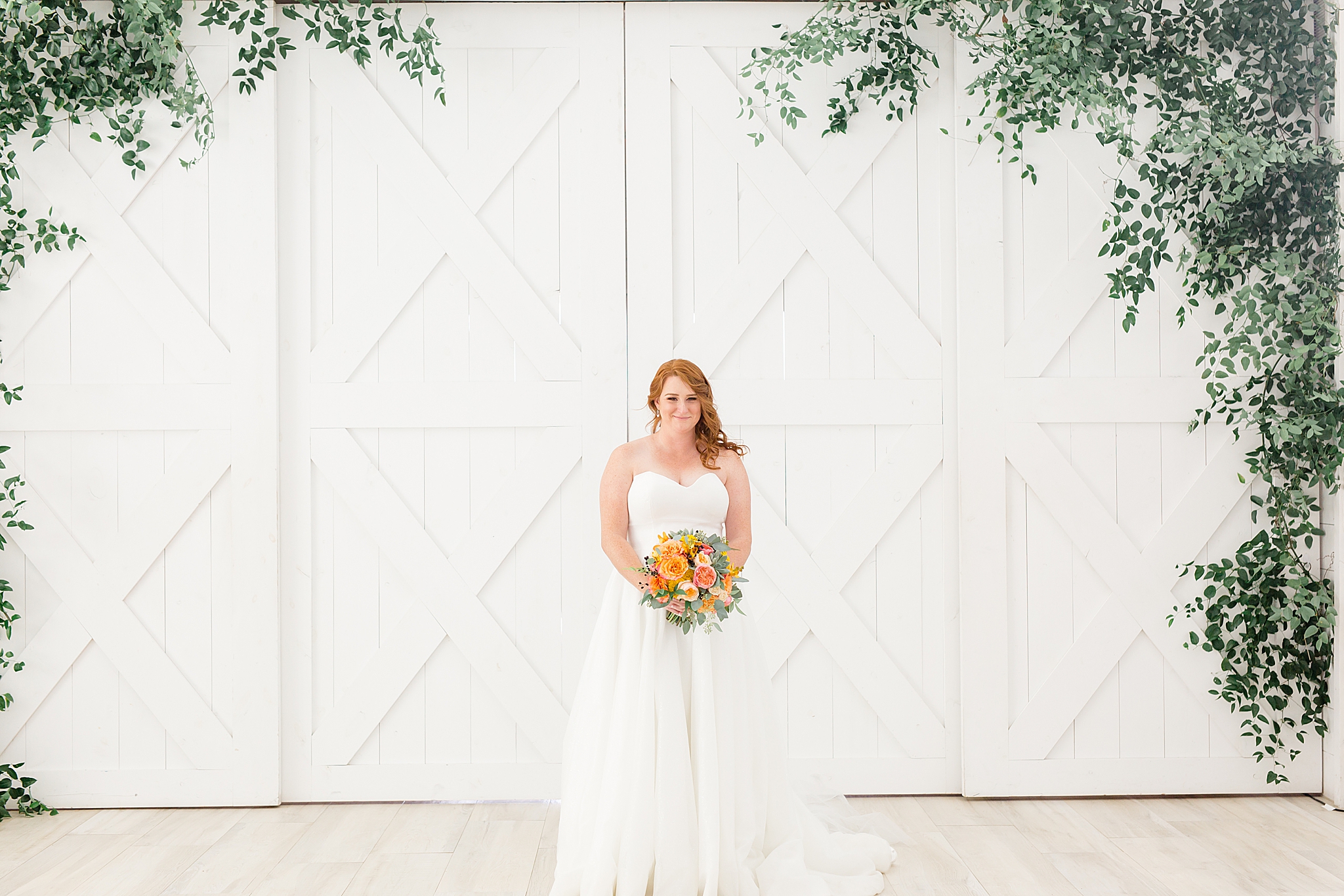 bride poses by barn doors at The Nest at Ruth Farms