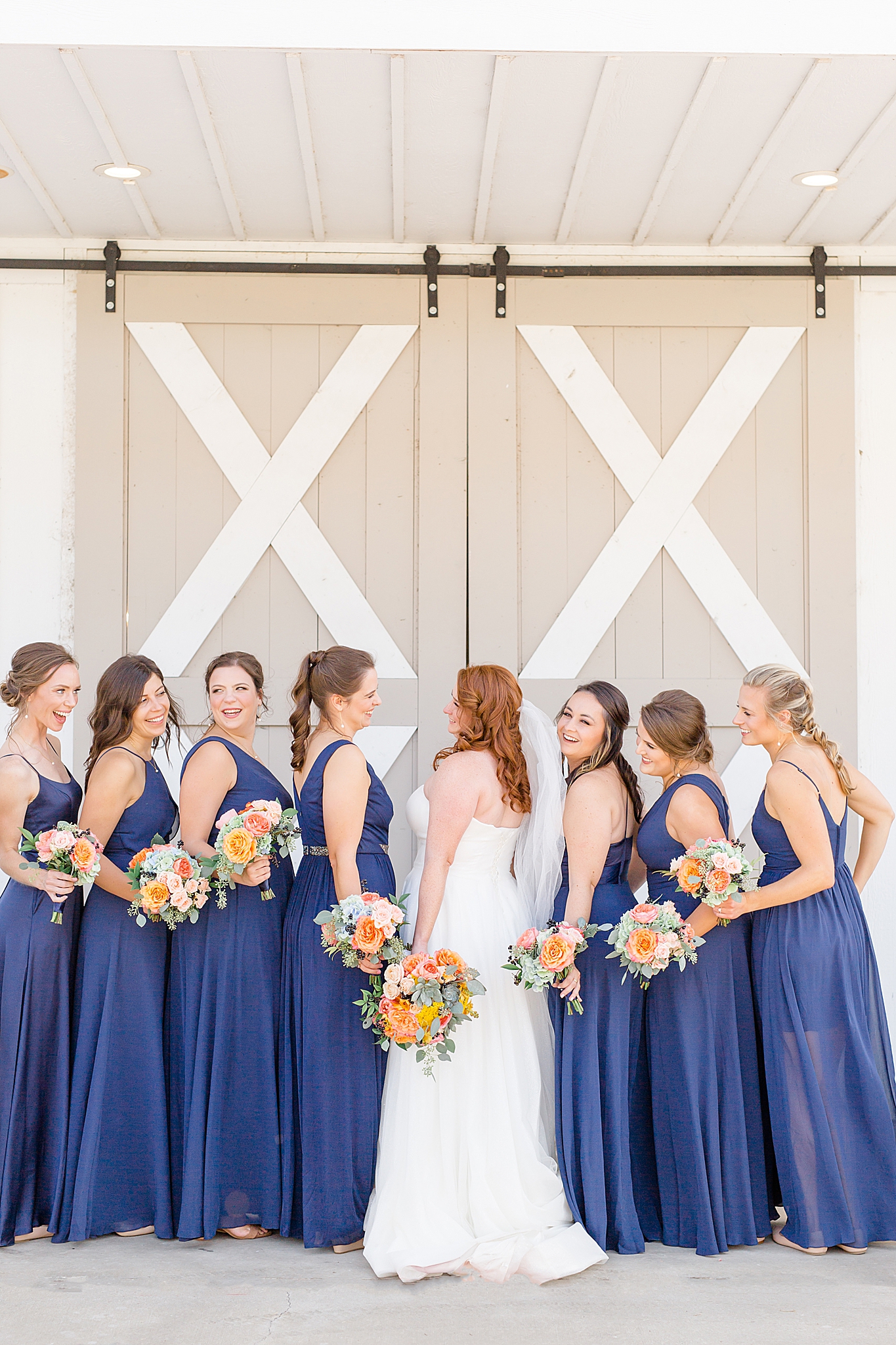 bride and bridesmaids laugh outside The Nest at Ruth Farms