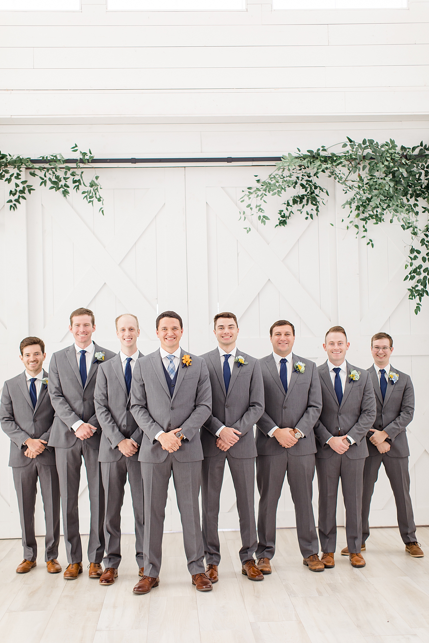 groomsmen pose with hands in front