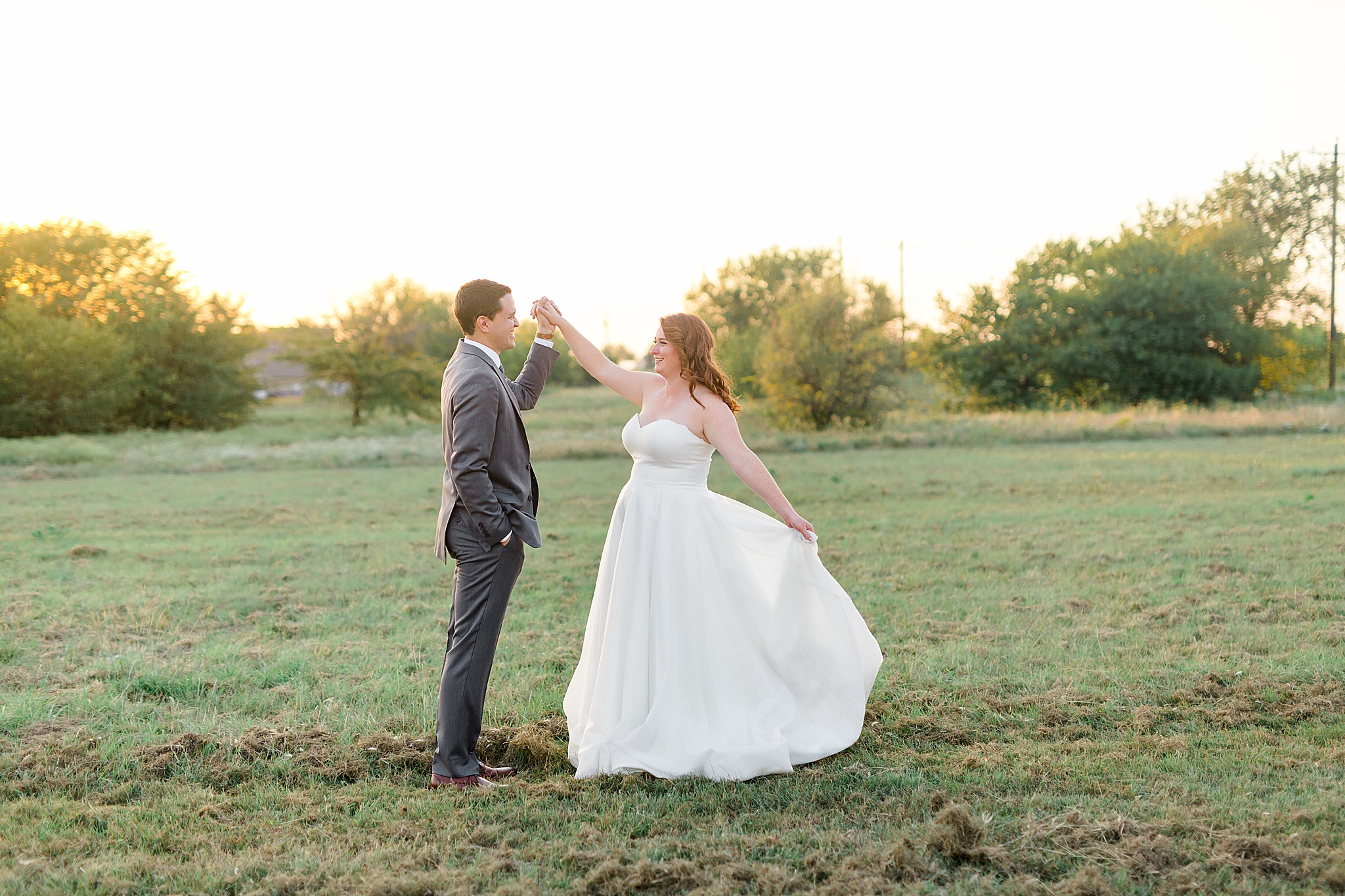 groom dances with bride at sunset