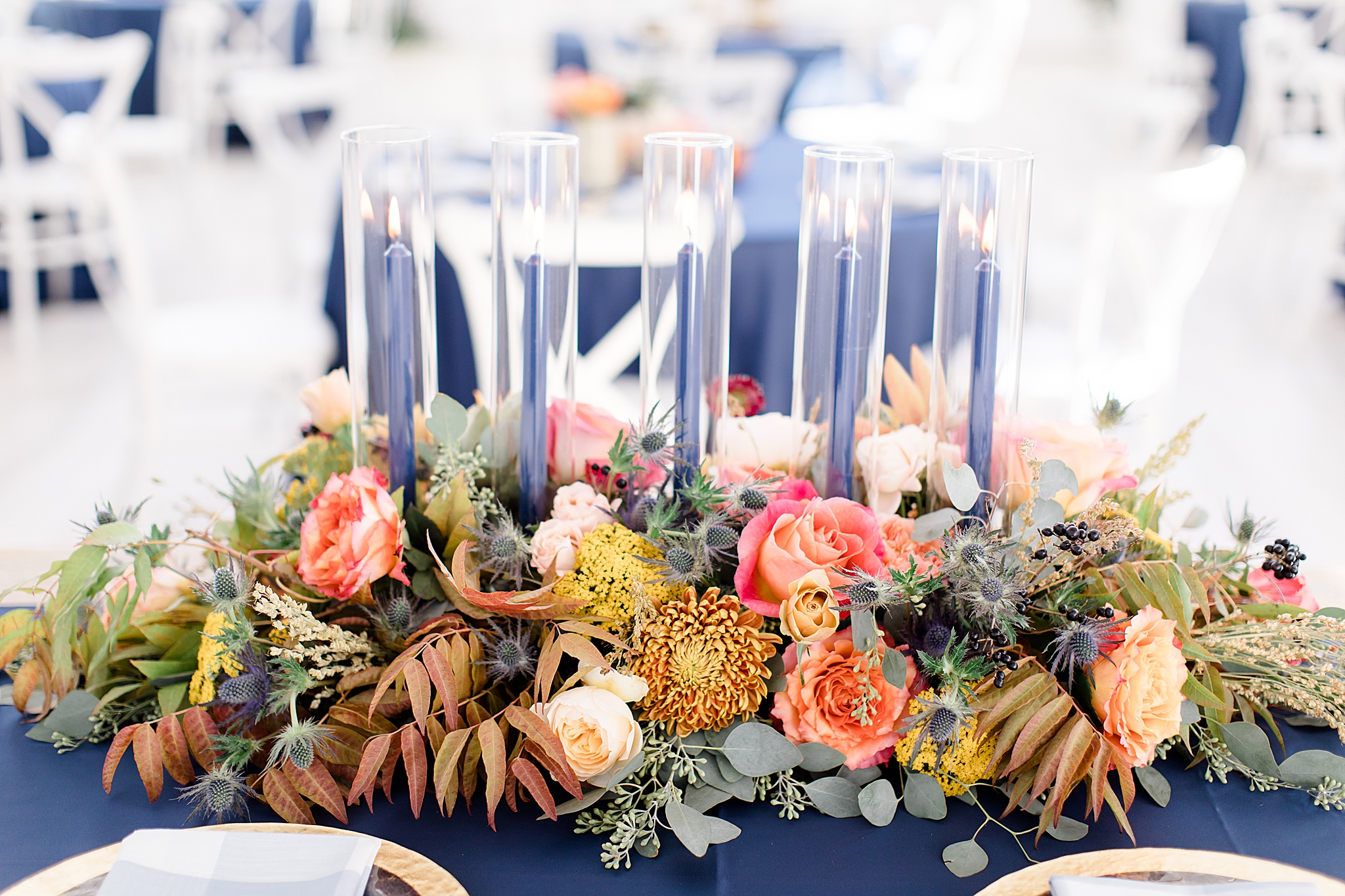 blue taper candles sit in floral centerpiece
