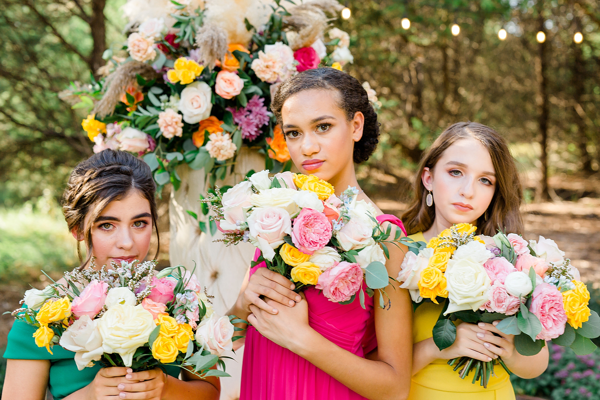 bridesmaids hold pastel bouquets by chins