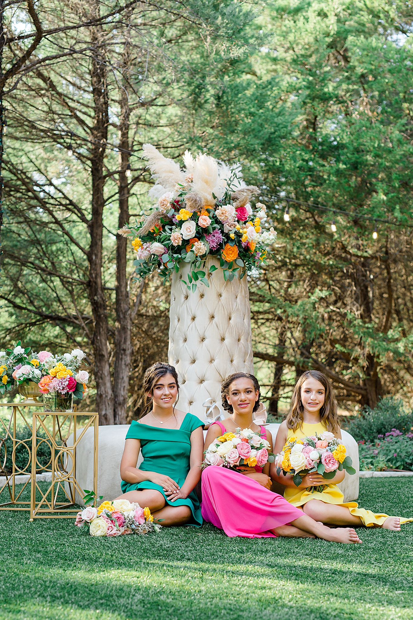 bridesmaids sit by floral display in Hidden Creek Events