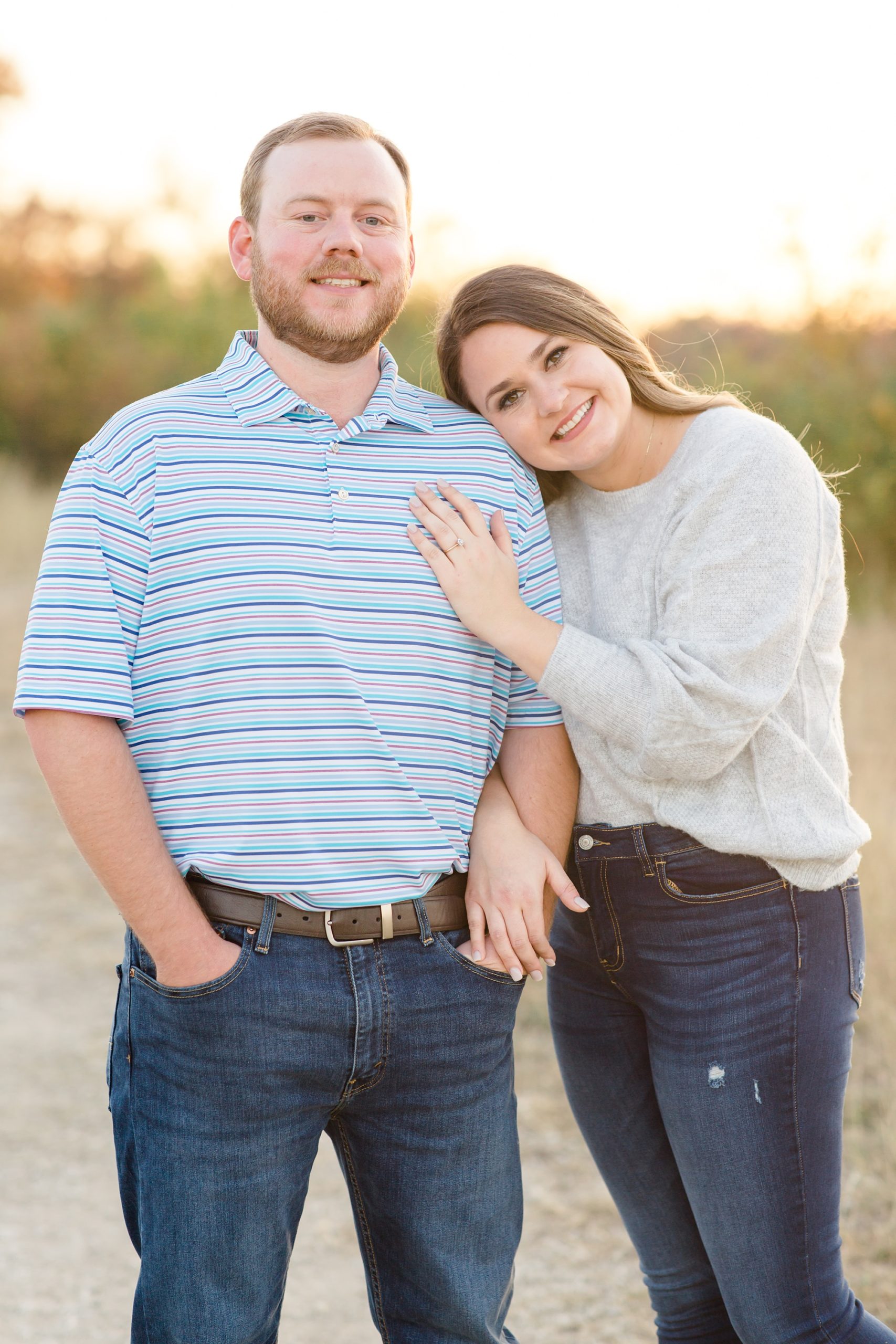 bride leans on groom's shoulder during Dallas TX engagement photos