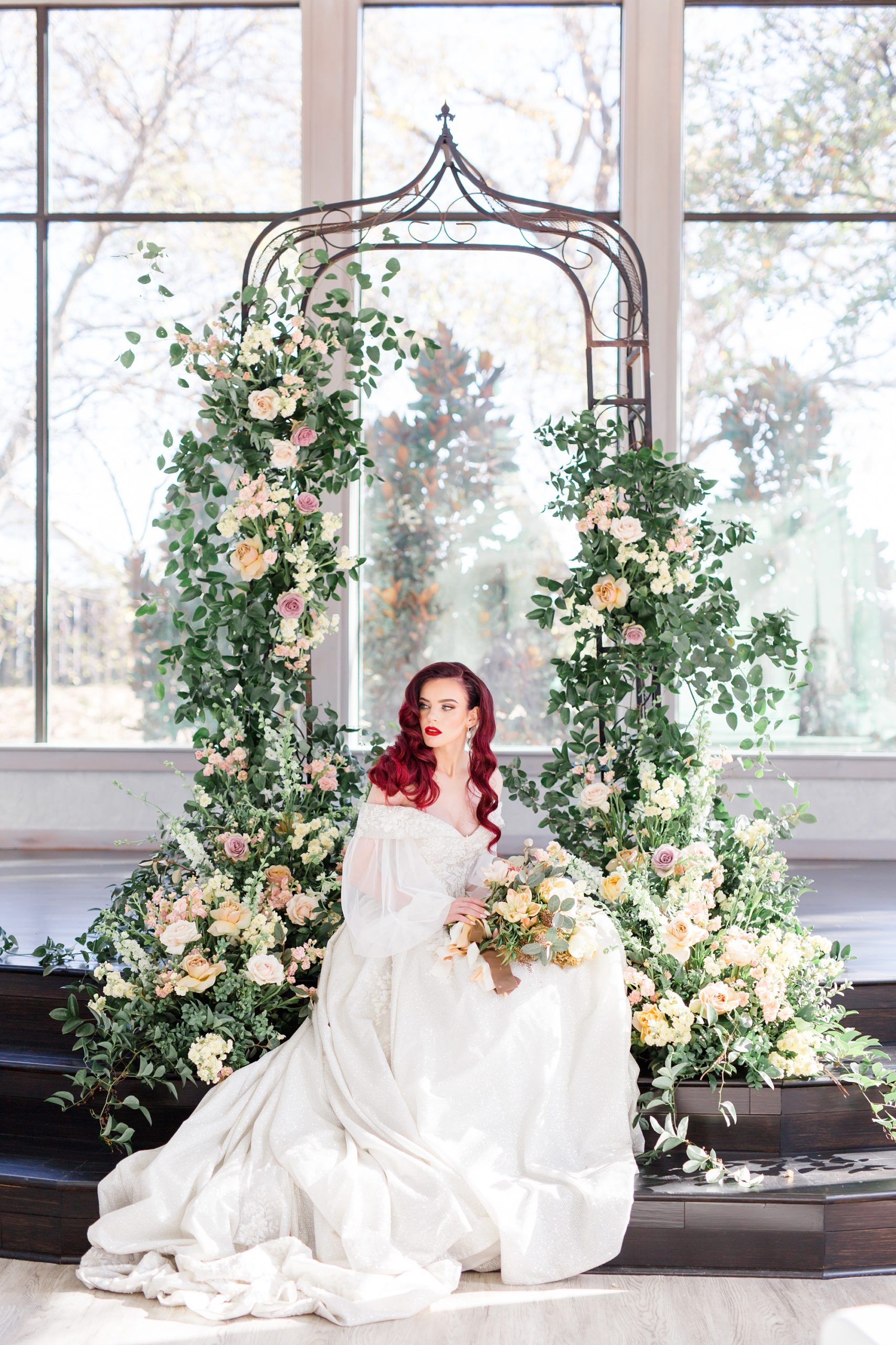 bride poses in front of Gothic arch at Brighton Abbey