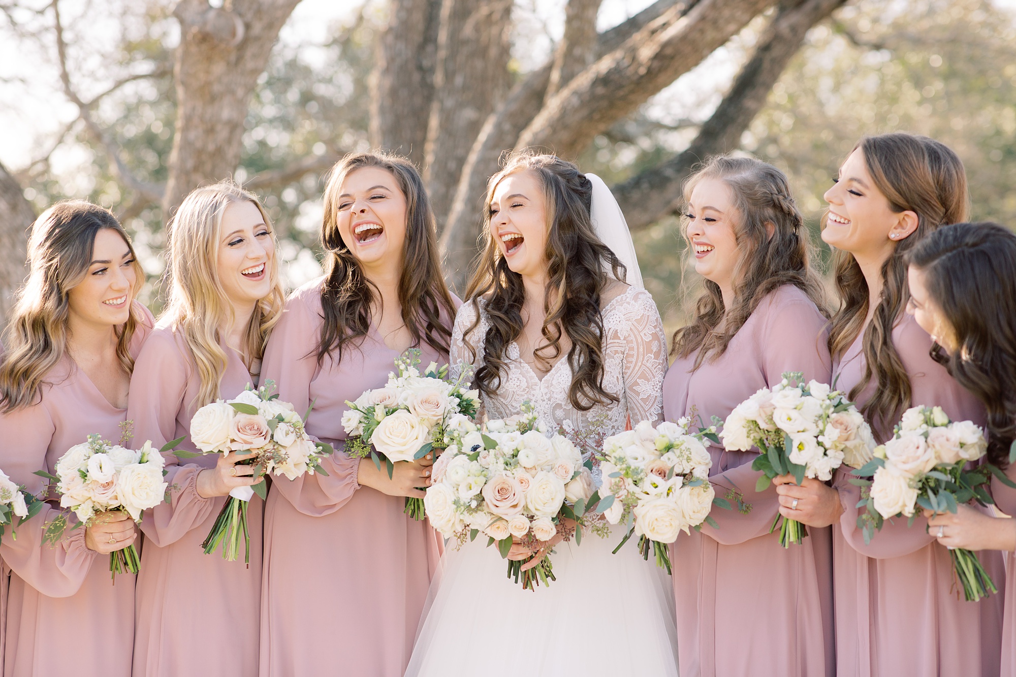 bride and bridesmaids in pink laugh