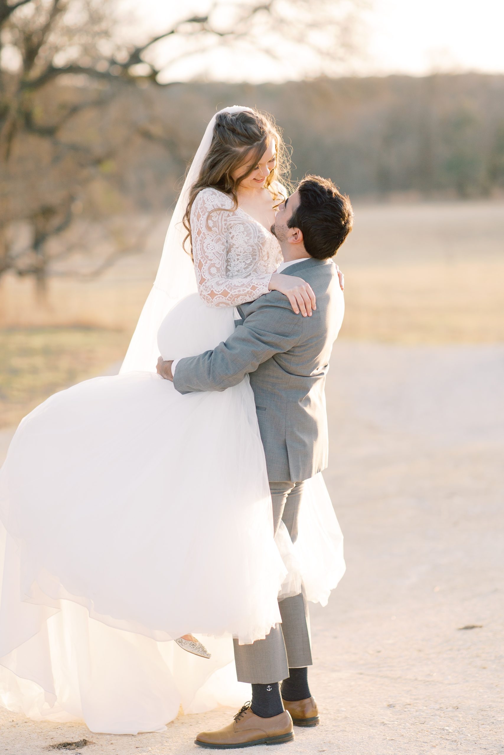groom lifts bride during sunset wedding portraits outside HighPointe Estate