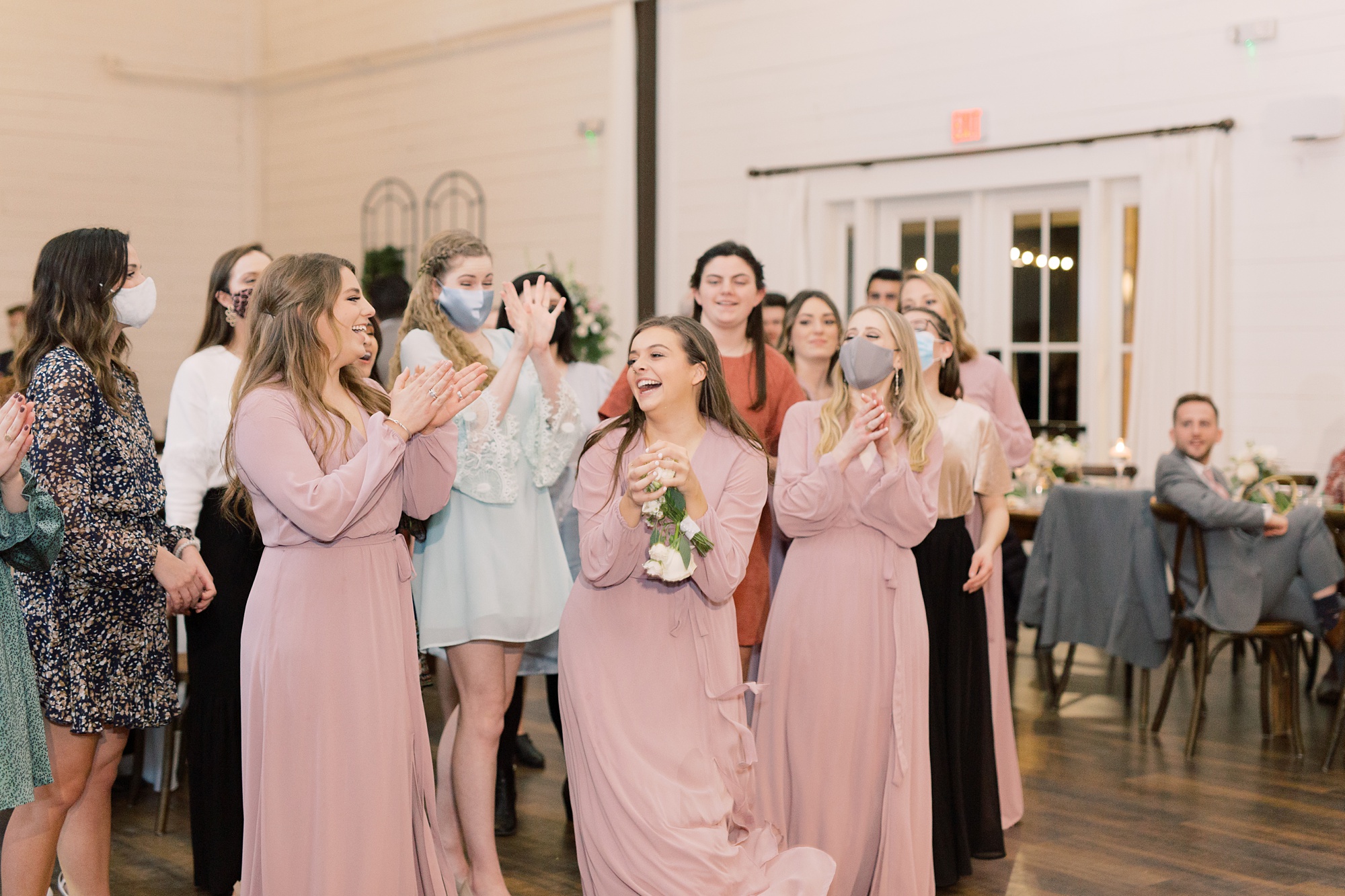 bridesmaids clap during bouquet toss at HighPointe Estate wedding reception