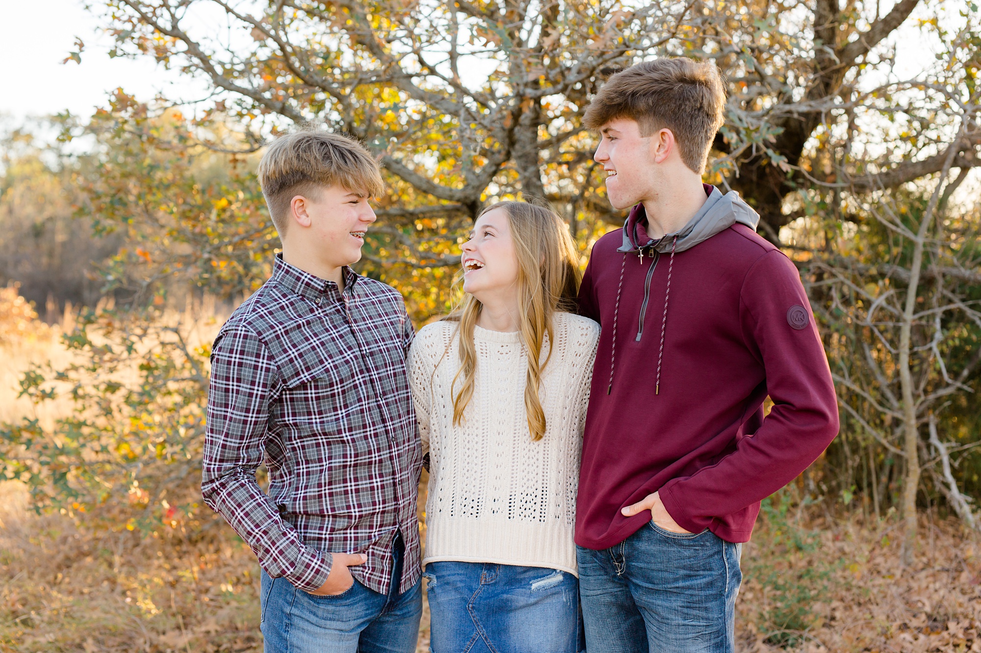 three siblings laugh while hugging in Flower Mound TX
