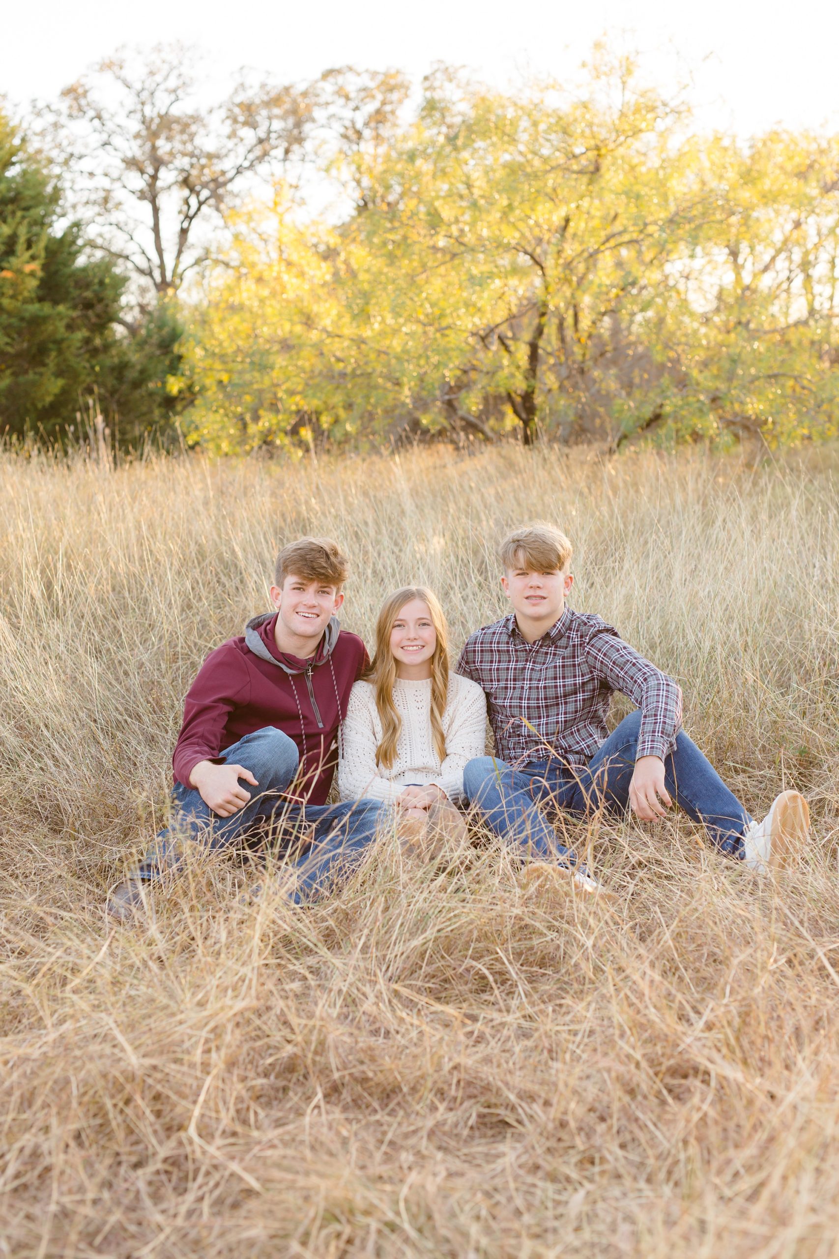 three siblings pose in grass during Murrell Park family session