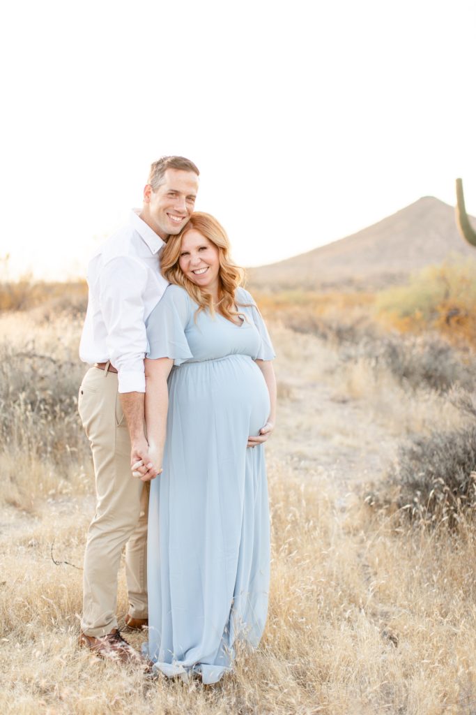 husband and wife pose in desert during Scottsdale AZ maternity session