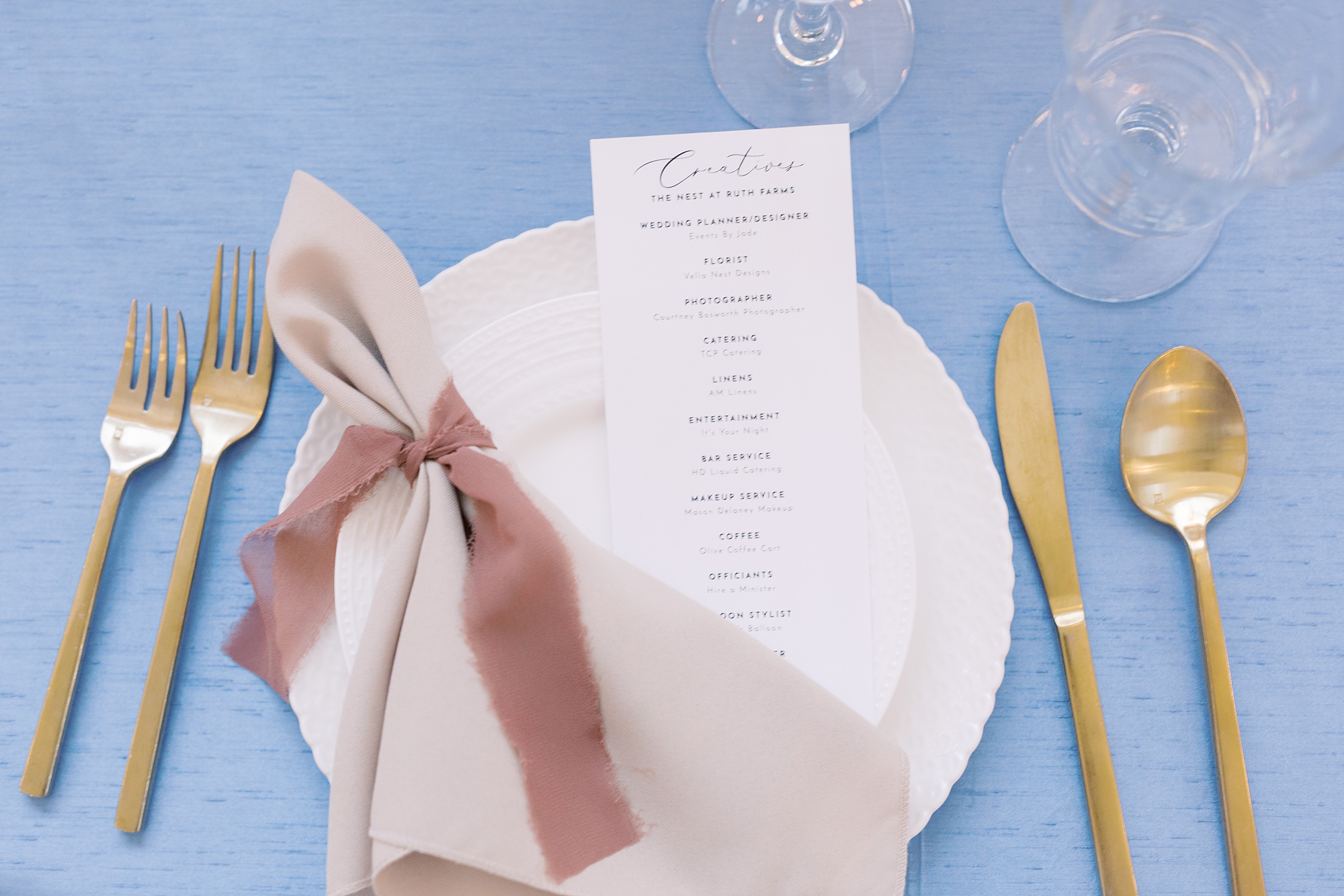 place settings with pale pink napkin and gold silverware