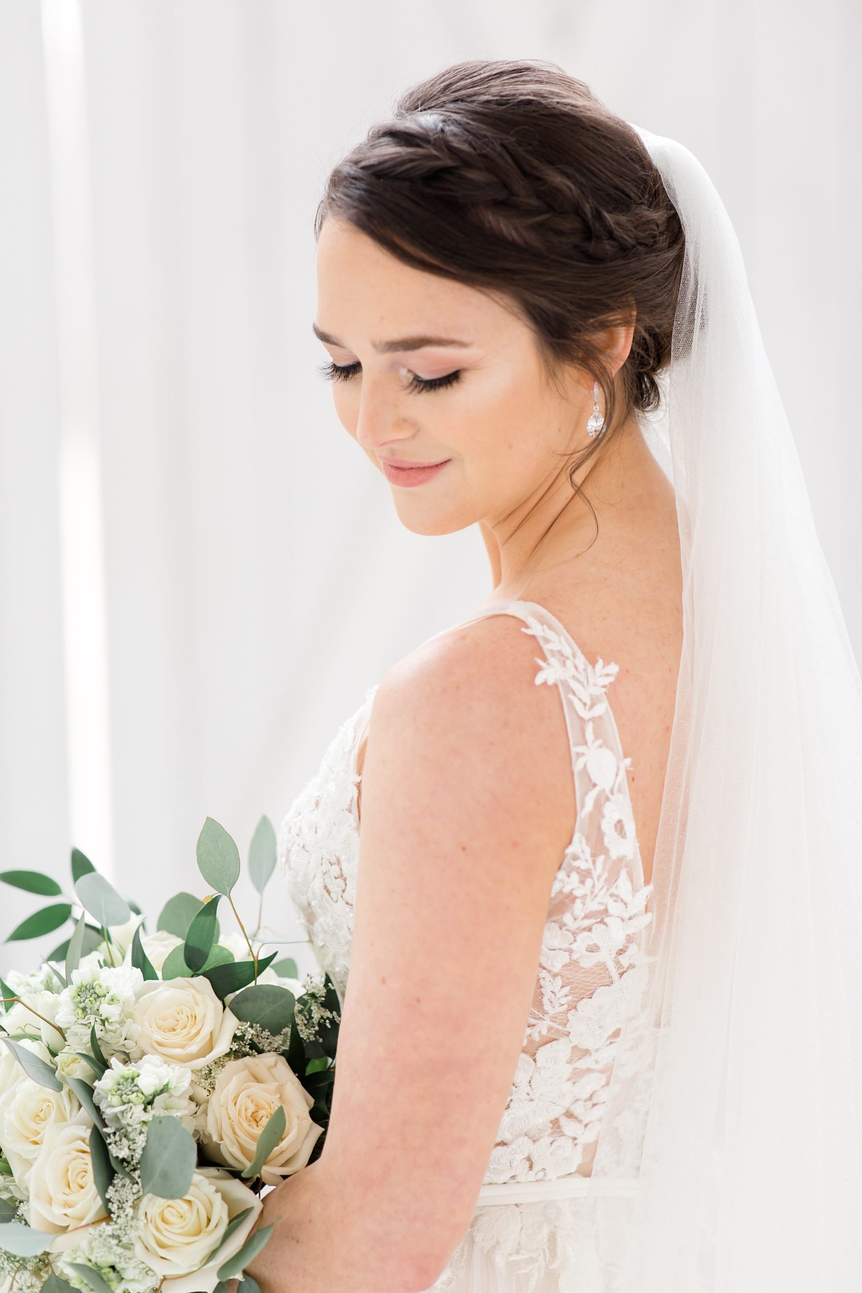 bride looks over shoulder with bouquet of flowers