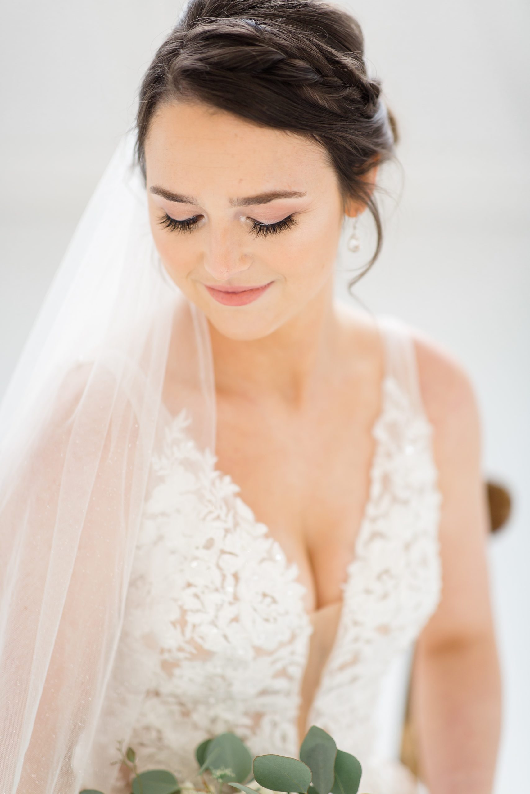 bride sits with veil draped around shoulder