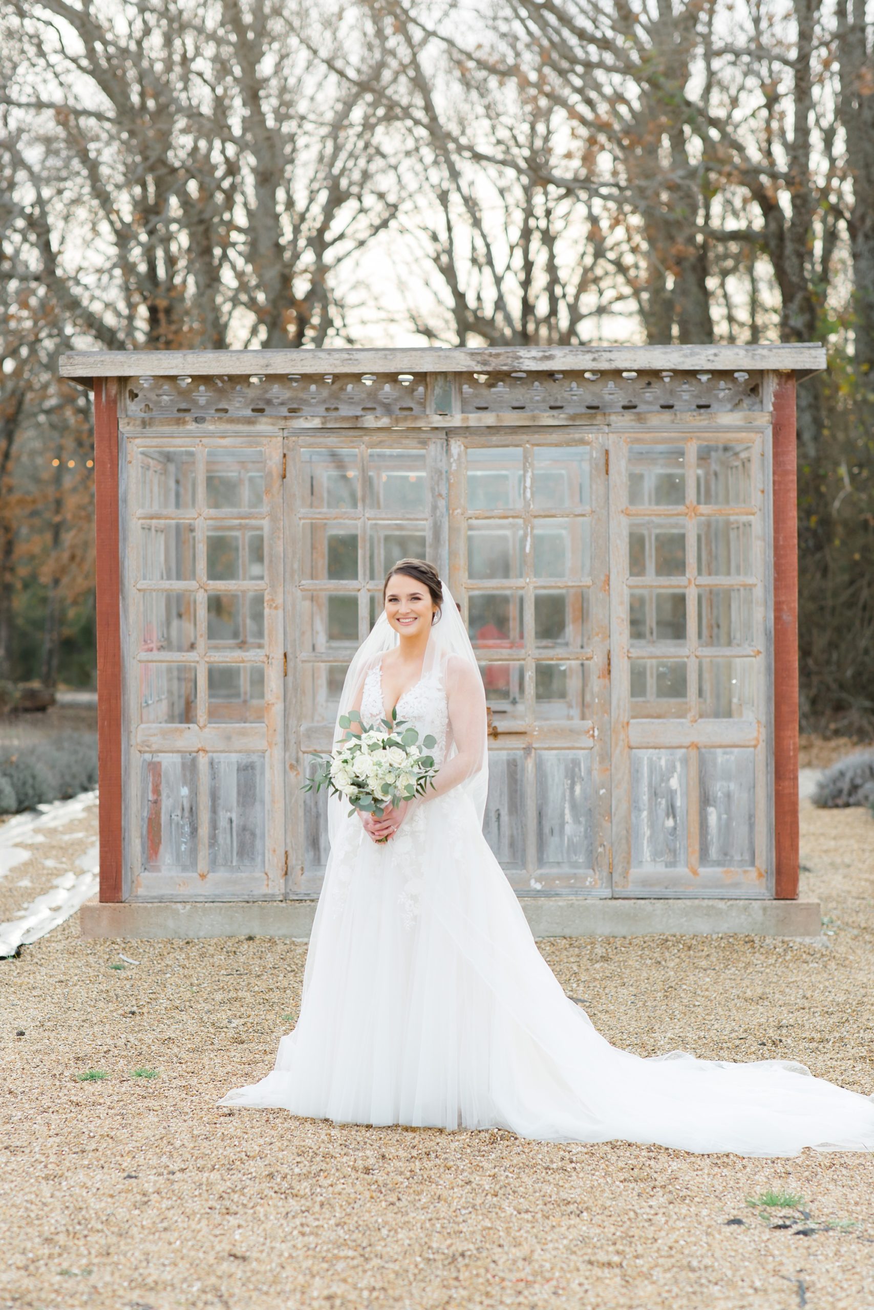 bride poses in front of glass box at The White Sparrow
