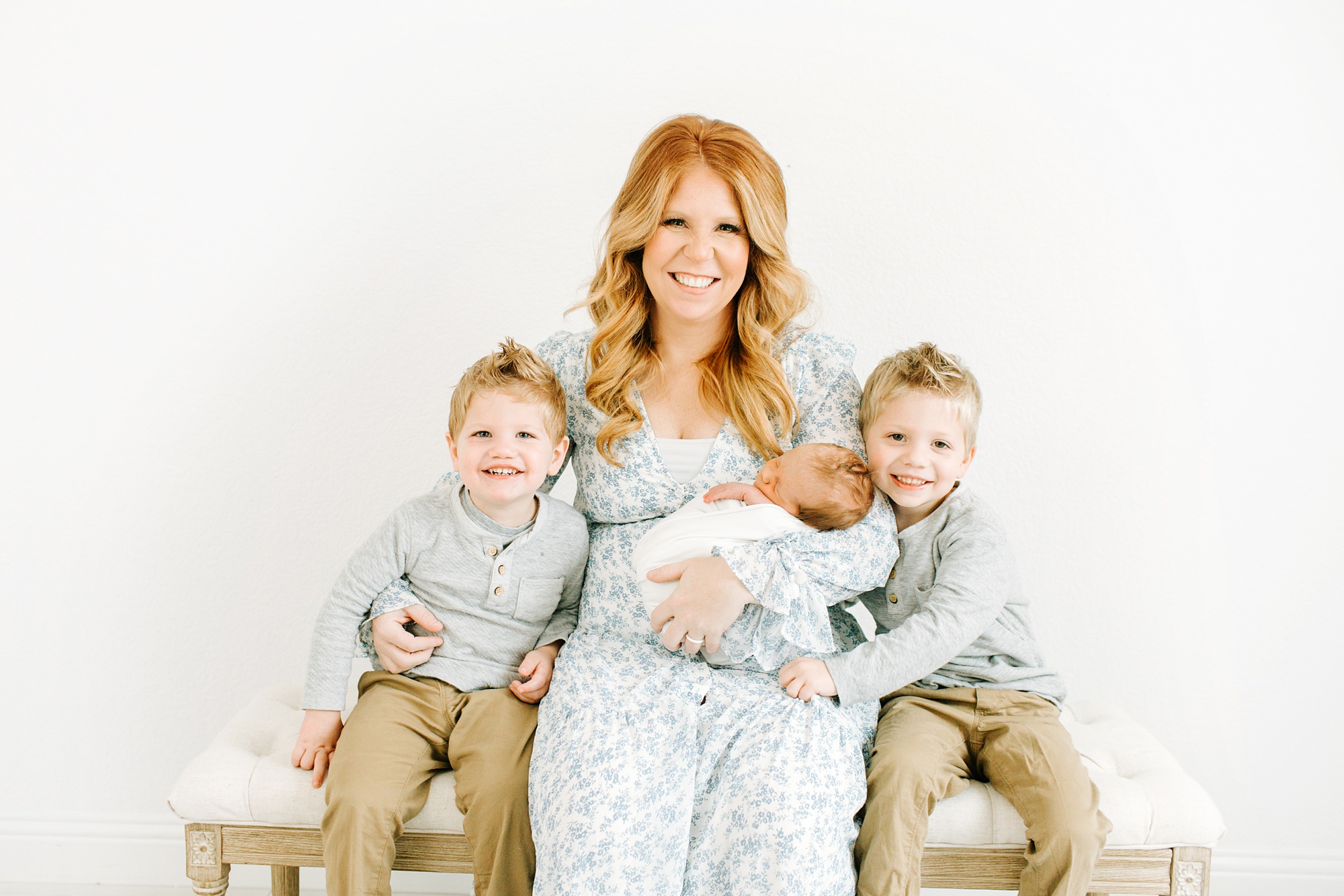 mom holds three sons during Dallas newborn portraits