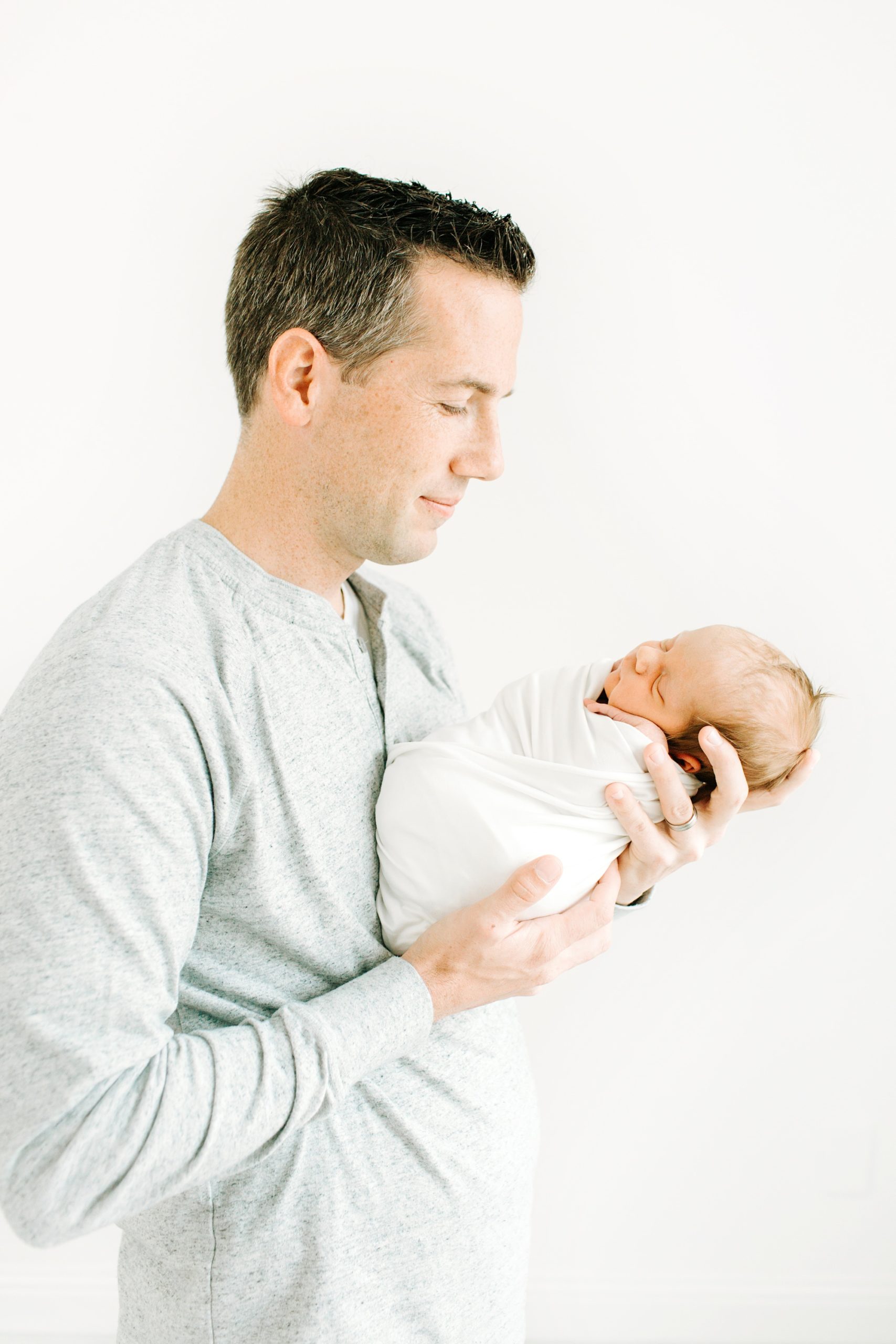 dad holds new baby boy during portraits in Dallas
