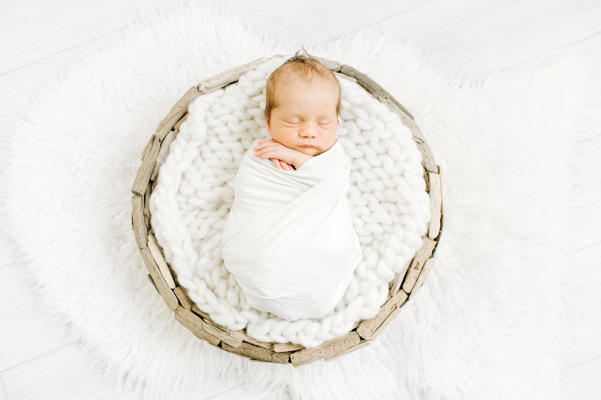 baby sleeps in basket during Dallas newborn portraits