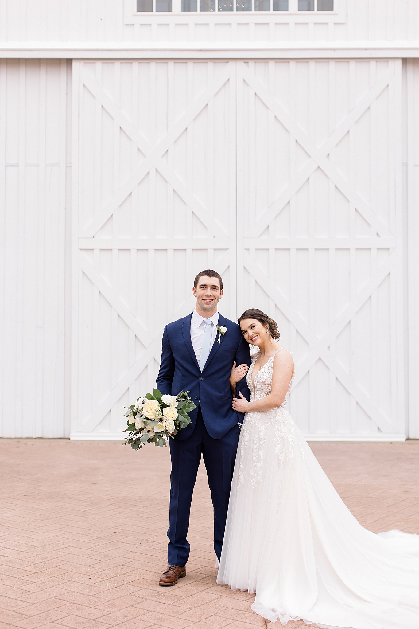 Dallas TX couple poses in front of white barn doors