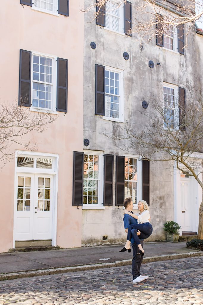 husband picks up wife during anniversary photos by historic homes