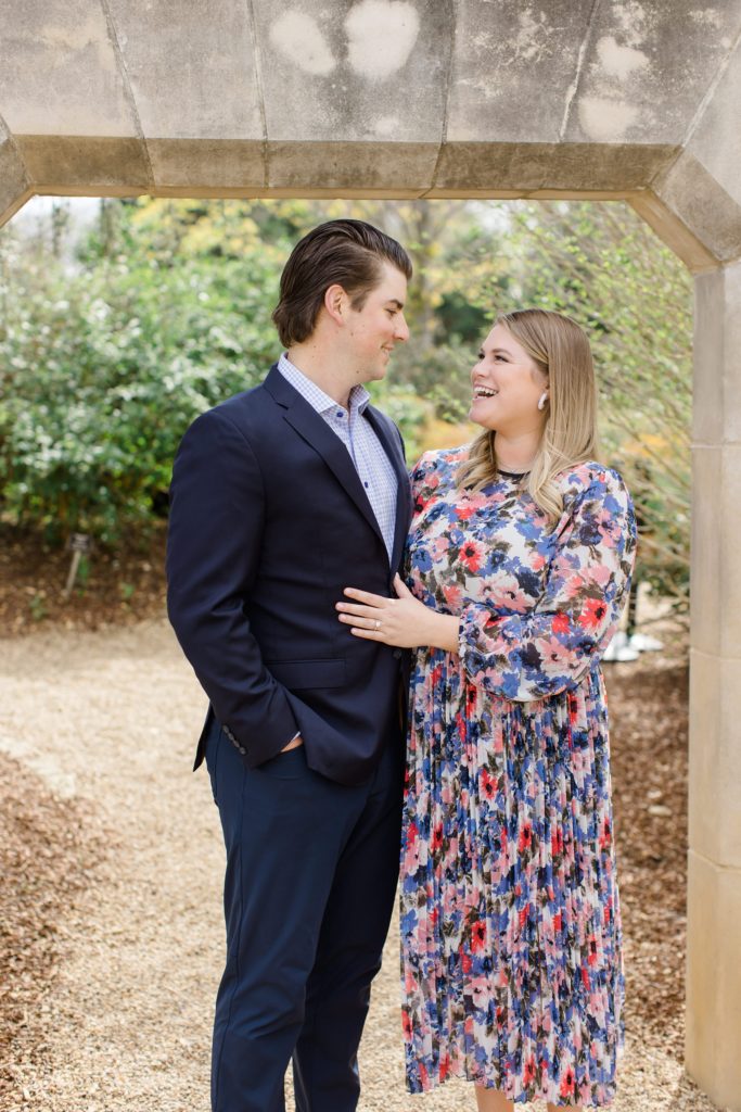 couple laughs during Texas engagement photos in garden