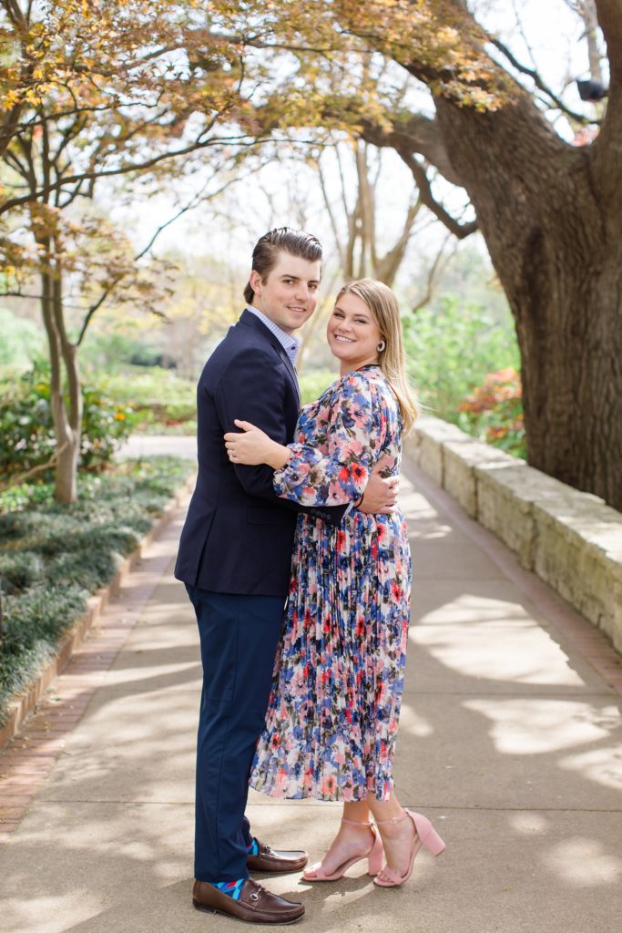 bride and groom pose under tree in Dallas Arboretum
