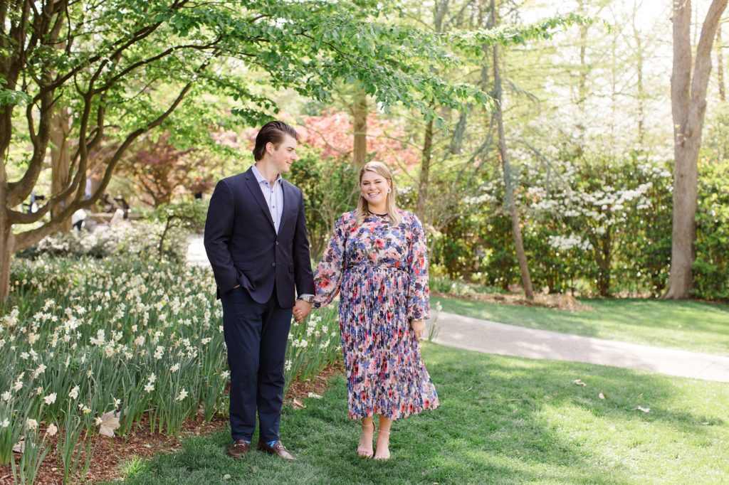 engaged couple walks through gardens of Dallas Arboretum