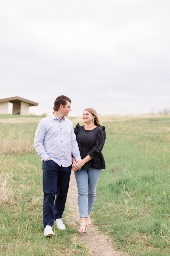 couple walks through field in Dallas TX