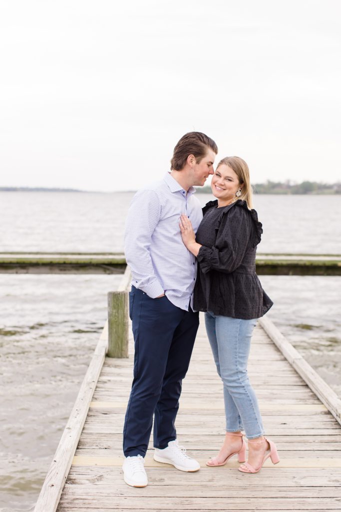 bride and groom pose by Texas waterfront during engagement session