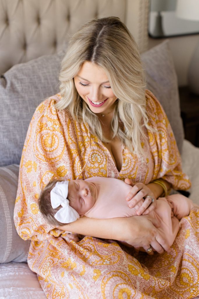 mom looks down at baby girl during Dallas lifestyle newborn portraits