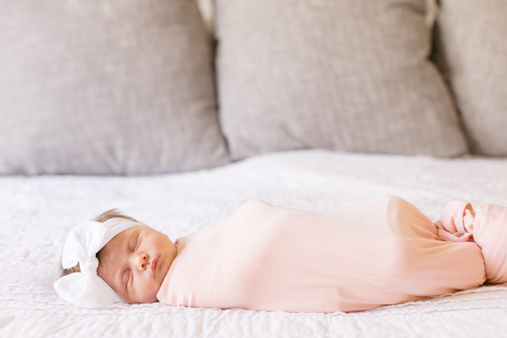 at home newborn session for baby girl in pink wrap