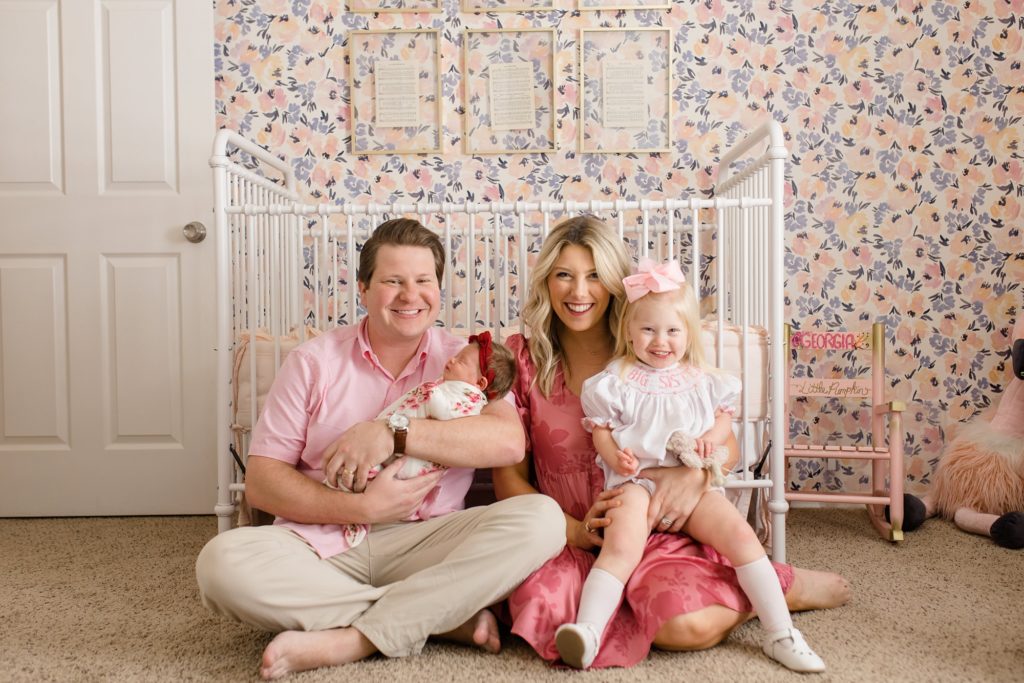 mom and dad pose with daughter during Dallas lifestyle newborn portraits
